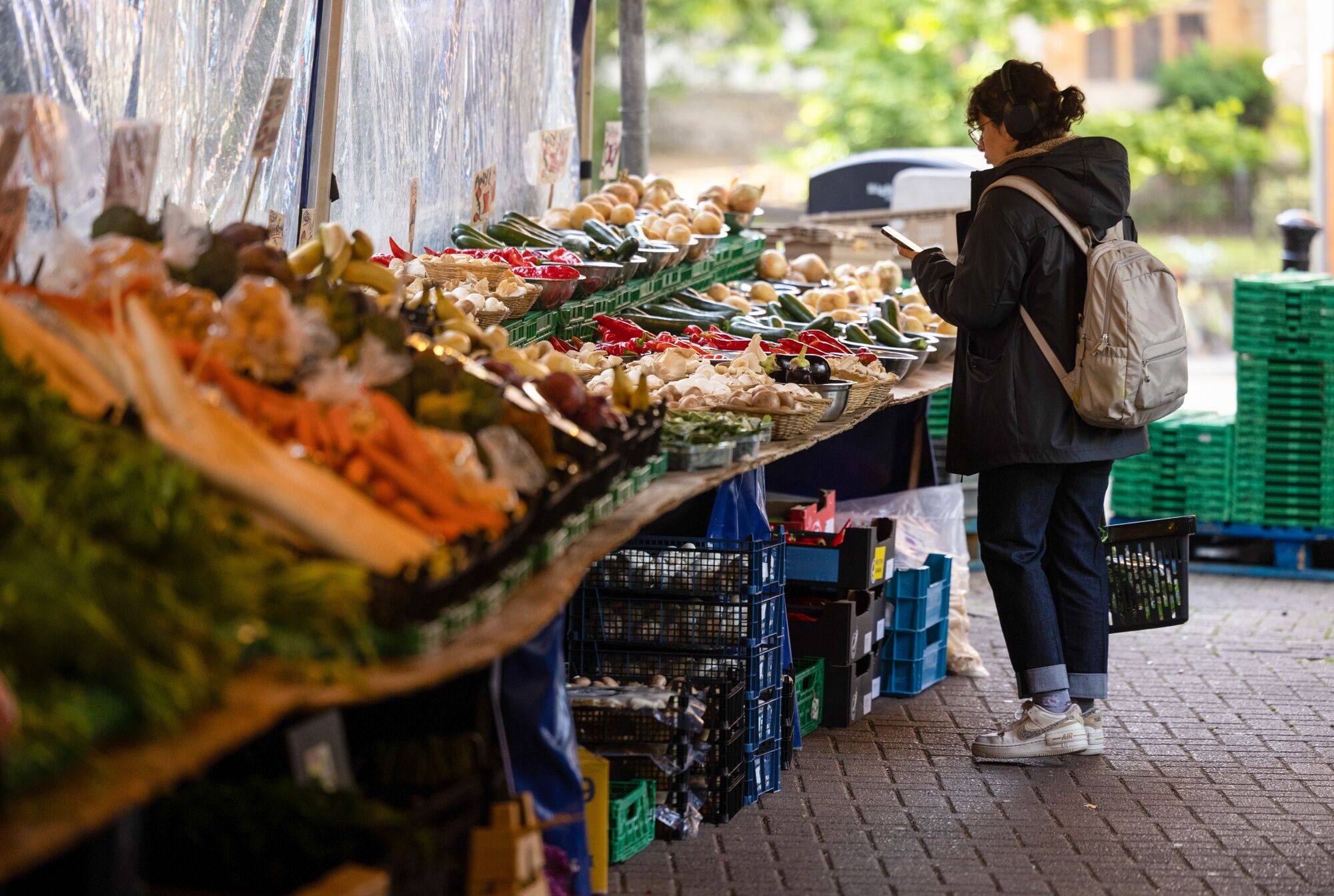 A customer chooses from a selection of fresh vegetables at a market in Oxford, England, on July 19. Britain’s inflation rate has cooled more than expected to the lowest level in more than a year, but there are still concerns the UK and other advanced economies have inflation that is well above their target rates. Photo: Bloomberg