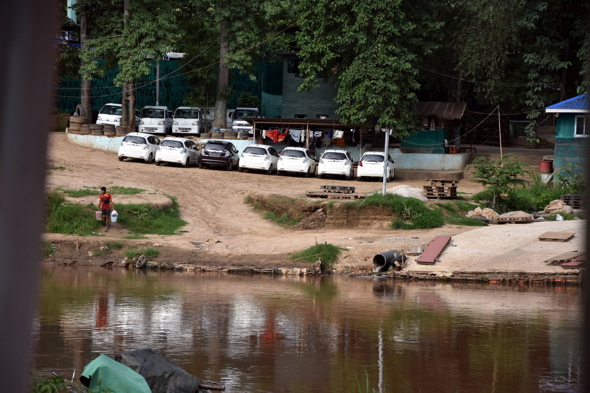 Smuggled cars await collection on the Myanmar bank of the Moei River, as seen from Thailand. Photo: Alastair McCready
