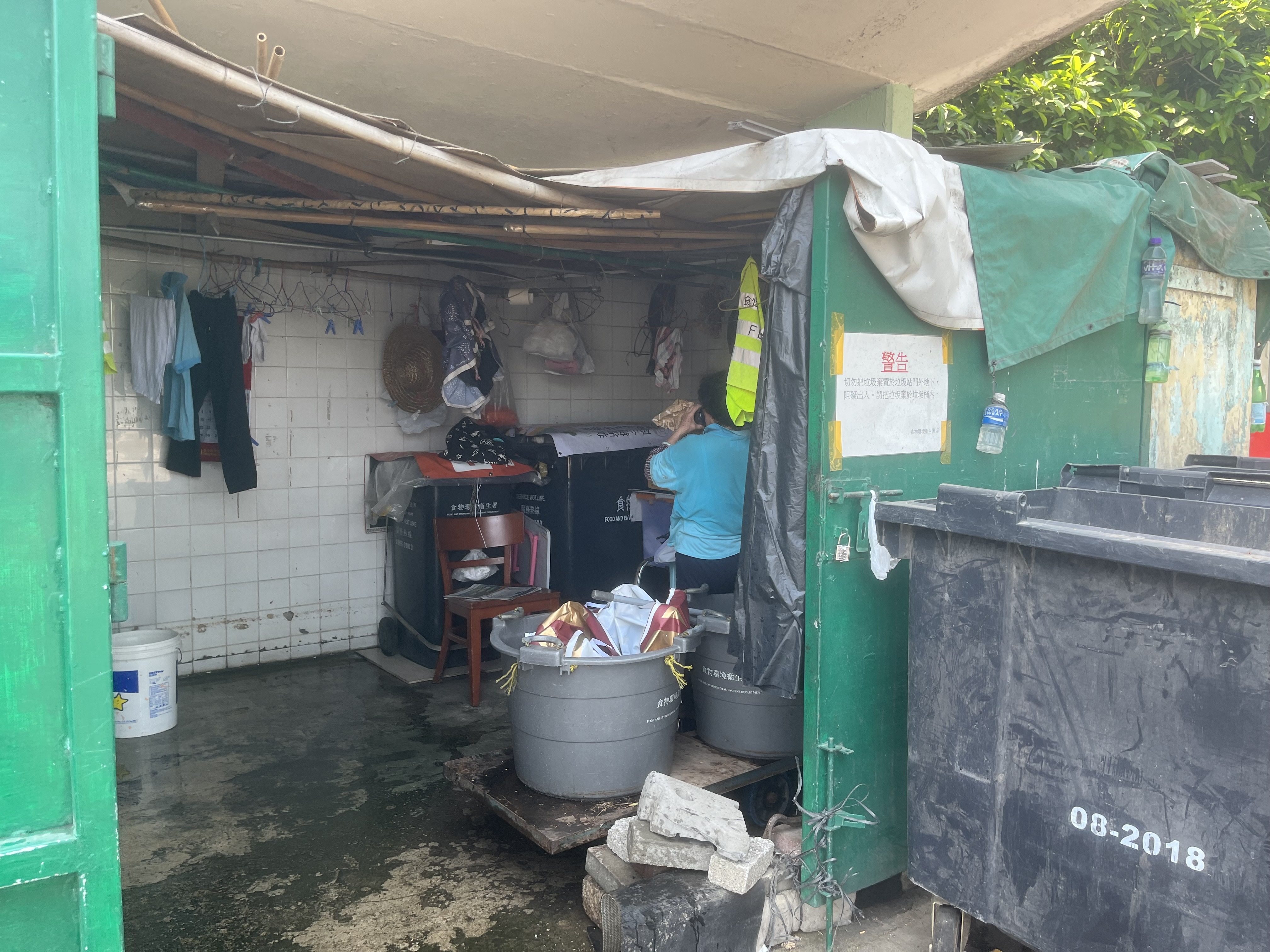 In rural parts of Yuen Long, an outsourced cleaner’s designated rest area is just a small trash station without windows or electricity, covered by a makeshift structure. Photo: Kelly Fung