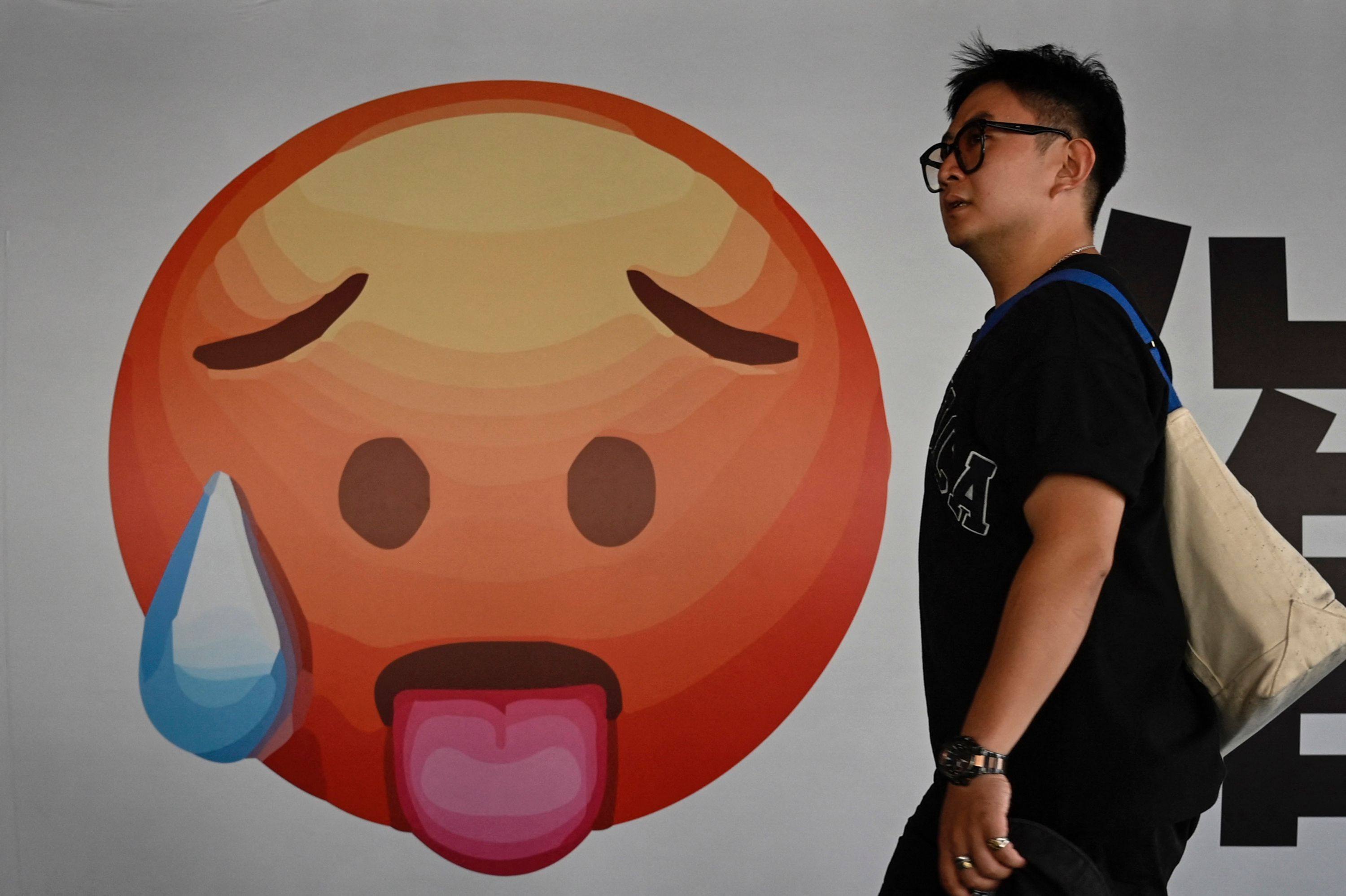 A man walks past an emoji at a shopping mall in Beijing on July 20. While the chances are good that the Chinese economy can hit the expected 5 per cent annual growth target, the government may have to step in more forcefully to nudge growth back on track. Photo: AFP