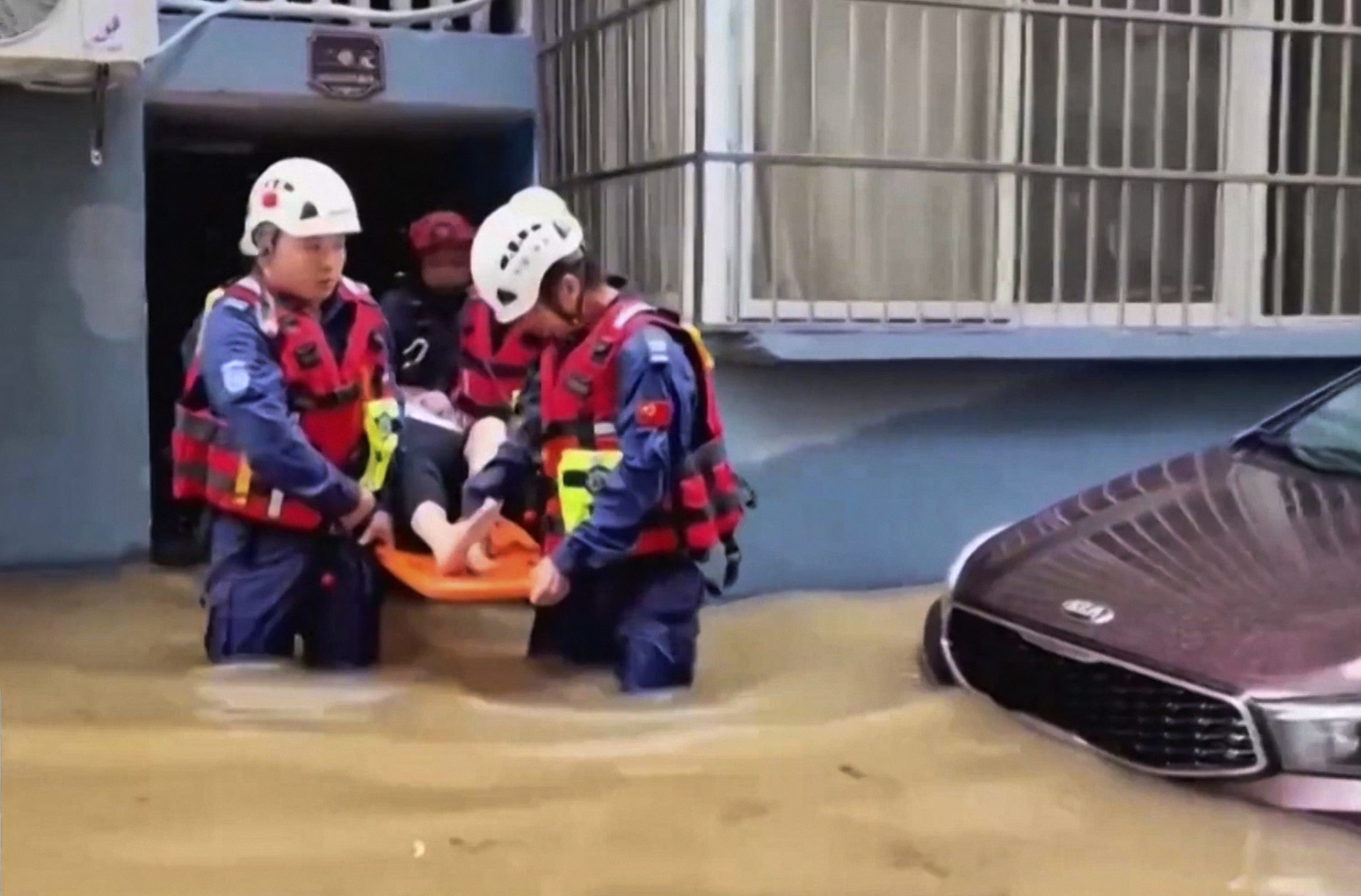 Rescuers aid a resident in a flood-hit village in eastern China’s Zhejiang province on Sunday.  Photo: CCTV via AP