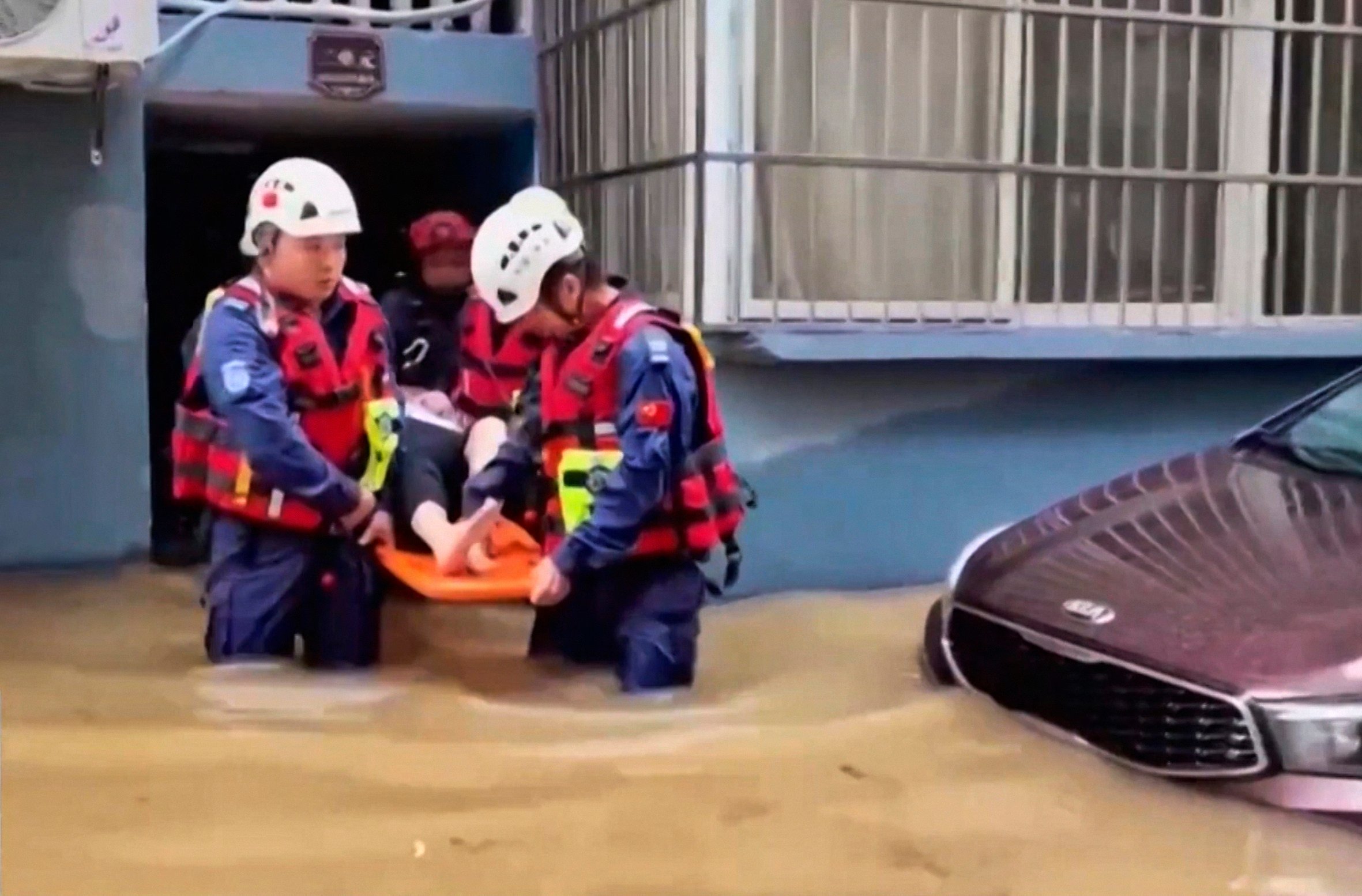 Rescuers aid a resident in a flood-hit village in eastern China’s Zhejiang province on Sunday.  Photo: CCTV via AP