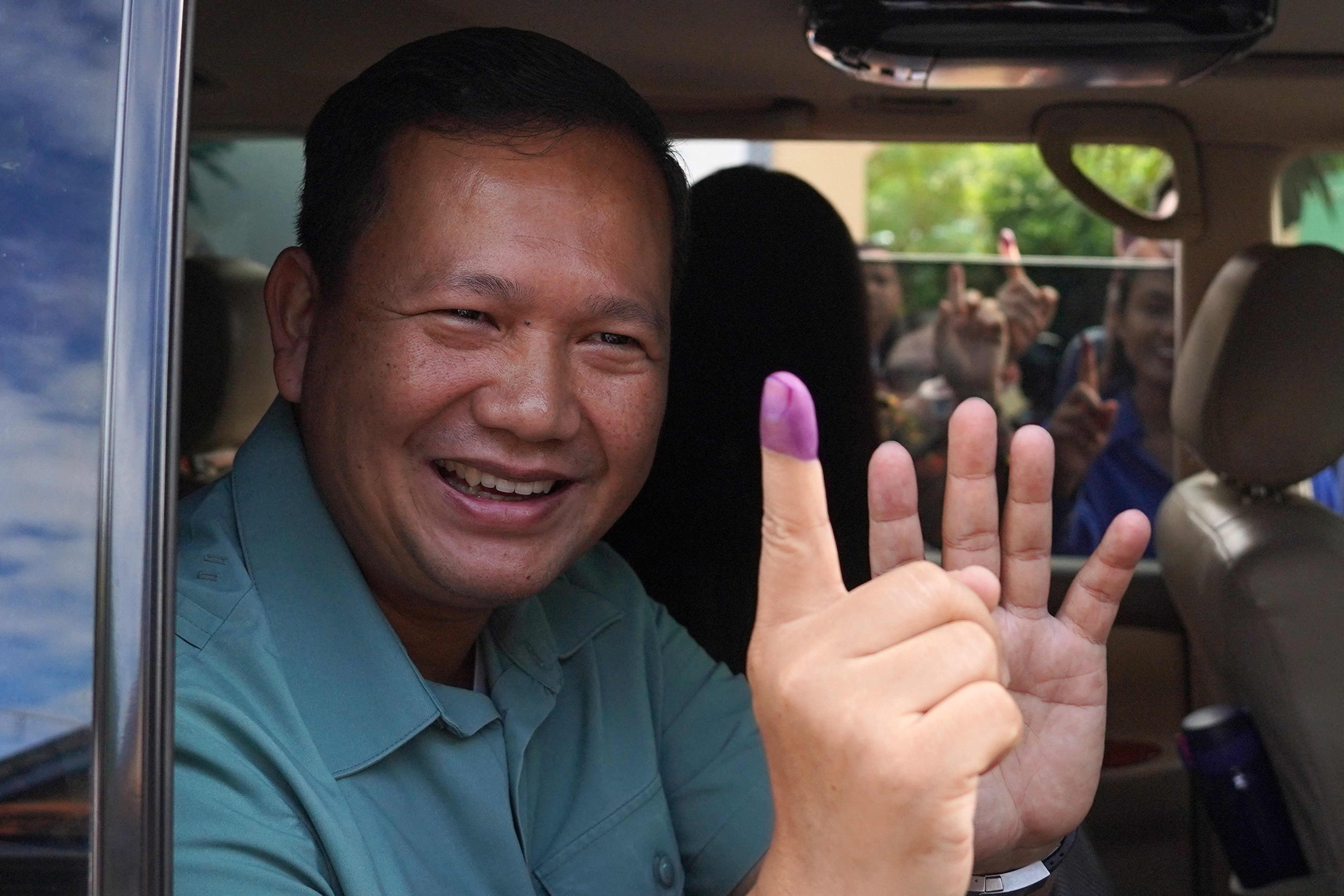 Hun Manet, commander of the Royal Cambodian Army and eldest son of Prime Minister Hun Sen, shows his finger after he casts his vote at a polling station on Sunday. Photo: AFP