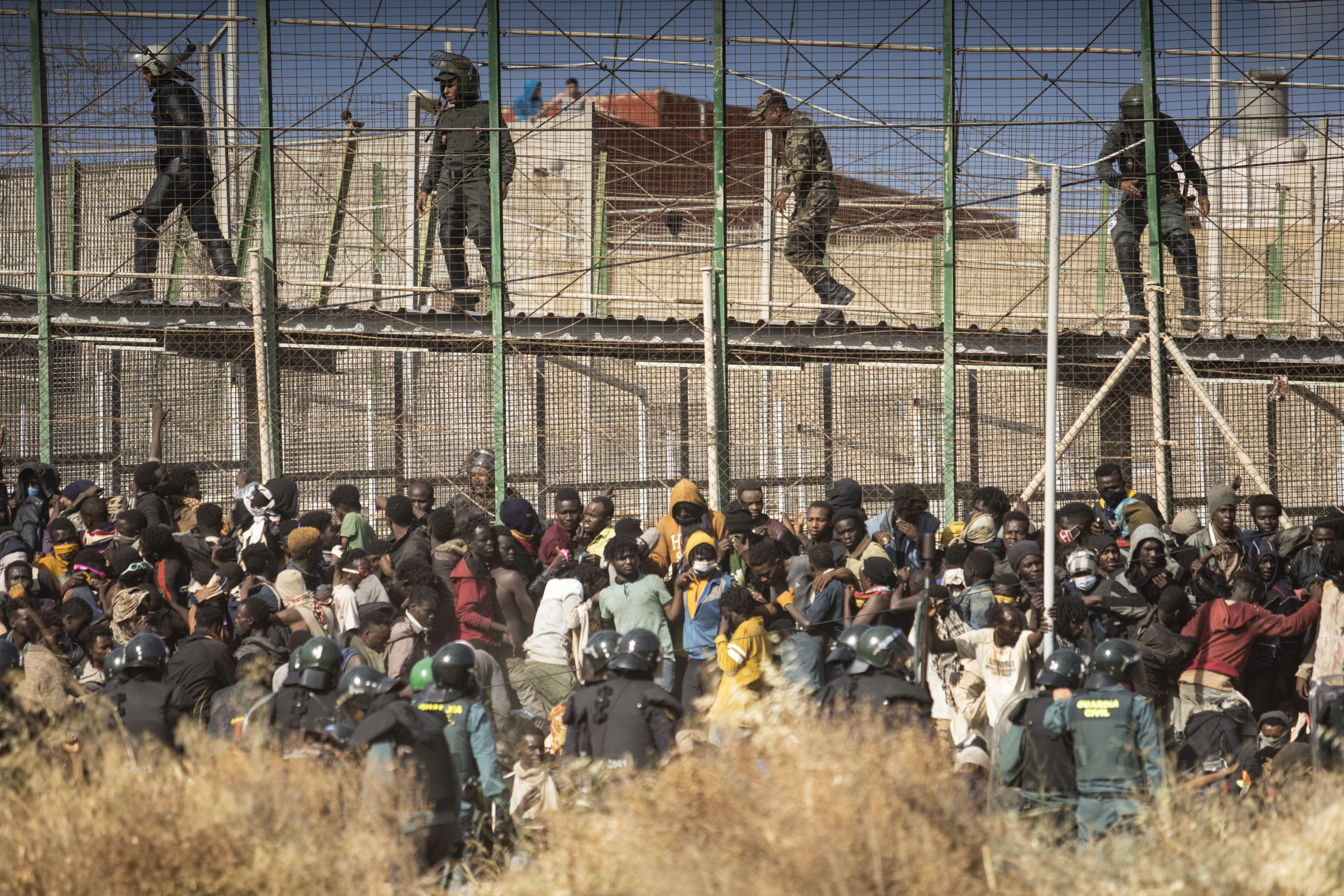 Riot police cordon off an area after migrants arrive on Spanish soil and attempt to cross fences separating the Spanish enclave of Melilla from Morocco, on June 24. Economic crises, and migrants fleeing war and environmental destruction, are challenging the governance of mainstream centre-left and centre-right parties alike in Europe. Photo: AP