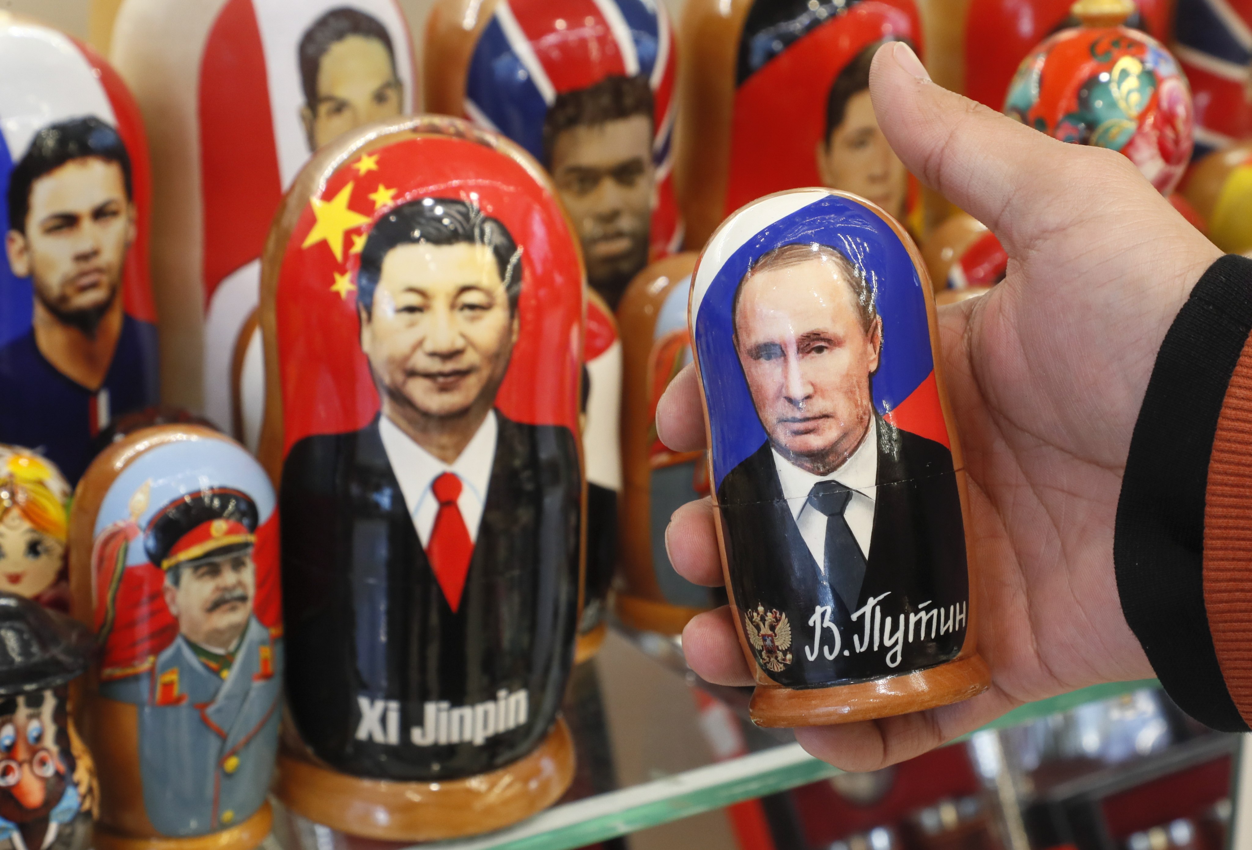 A man examines Russian matryoshka dolls with portraits of Russian President Vladimir Putin and Chinese President Xi Jinping at a street souvenir shop in Moscow in March. Photo: EPA-EFE
