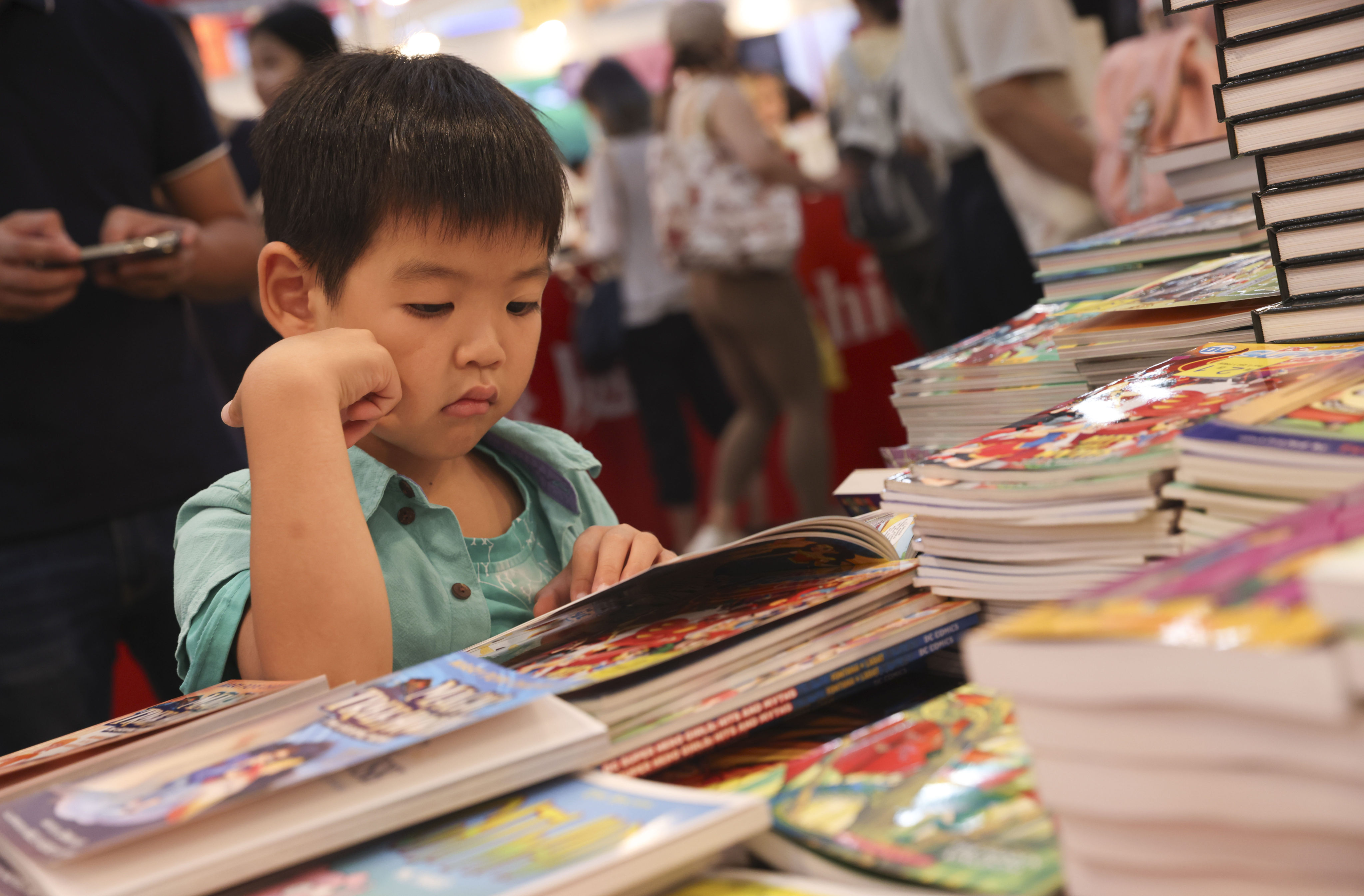 A young reader peruses a book during Hong Kong Book Fair 2023. Drawing nearly 1 million attendees, the event continued the city’s return to pre-pandemic life. Photo: Yik Yeung-man