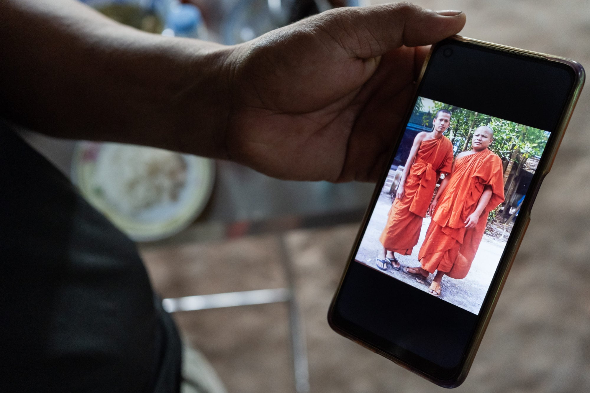 Meas shows a photo from his time as a monk. Photo: Andy Ball