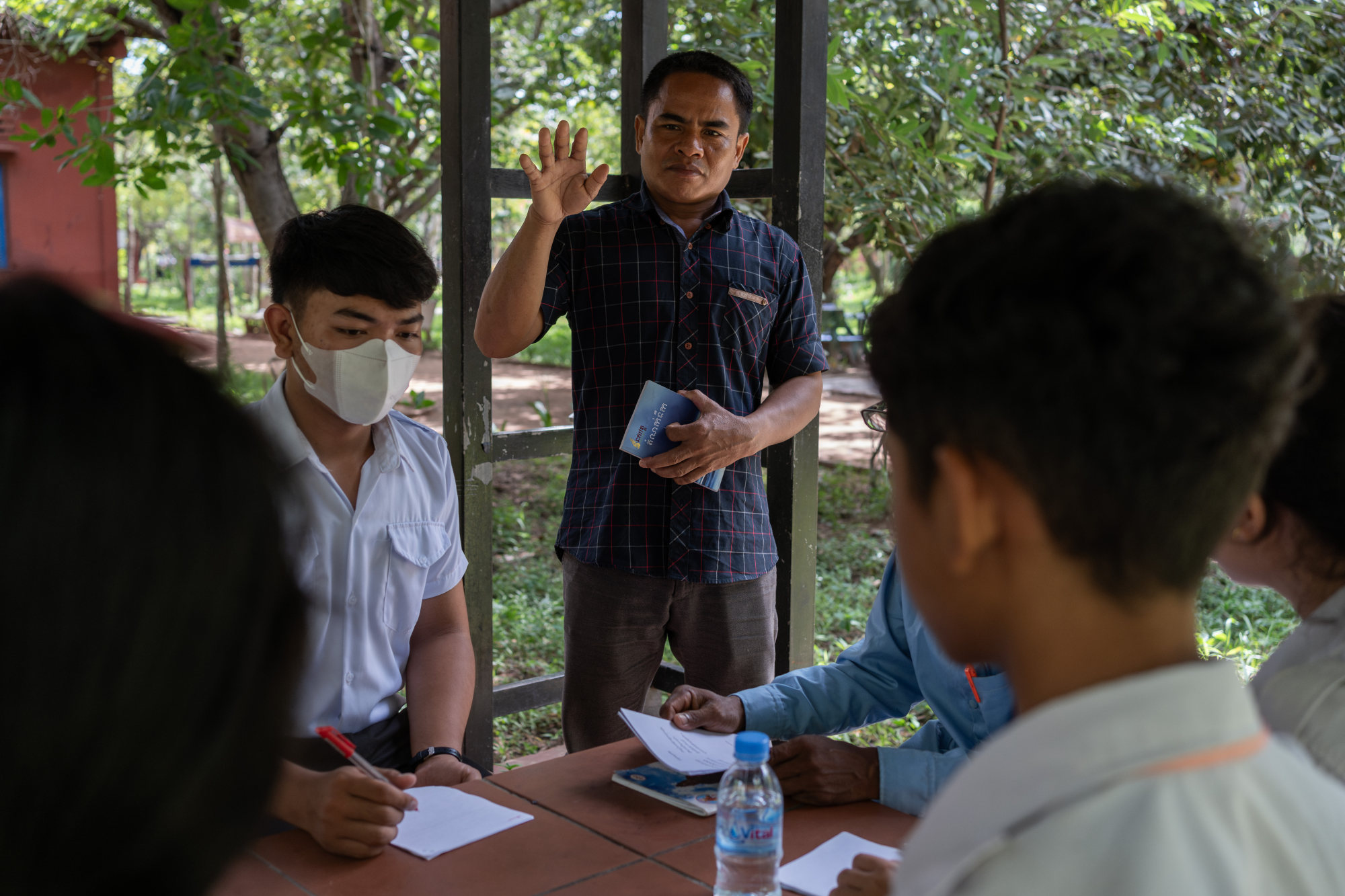 Meas holds his 2011 collection titled “Drop of Water” after reading his poem Raining in the Wrong Place to high school students during a workshop organised by local NGO PEN Cambodia. Photo: Andy Ball