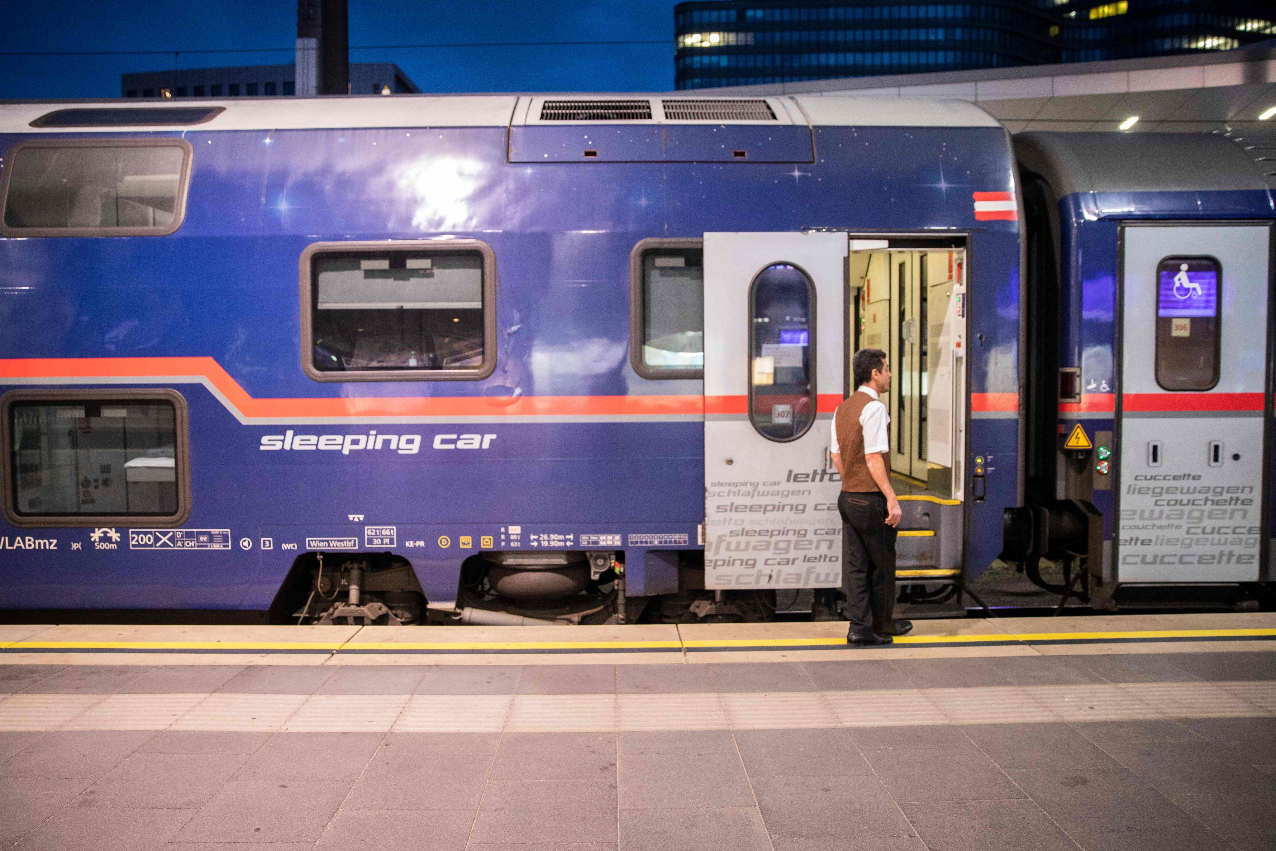 A train attendant stands in front of a sleeping car of the Nightjet train line Vienna–Venice (-Zurich) before departure, at the main station in Vienna, Austria. Night trains have made a comeback in Europe thanks to their low-carbon footprint. Photo: AFP