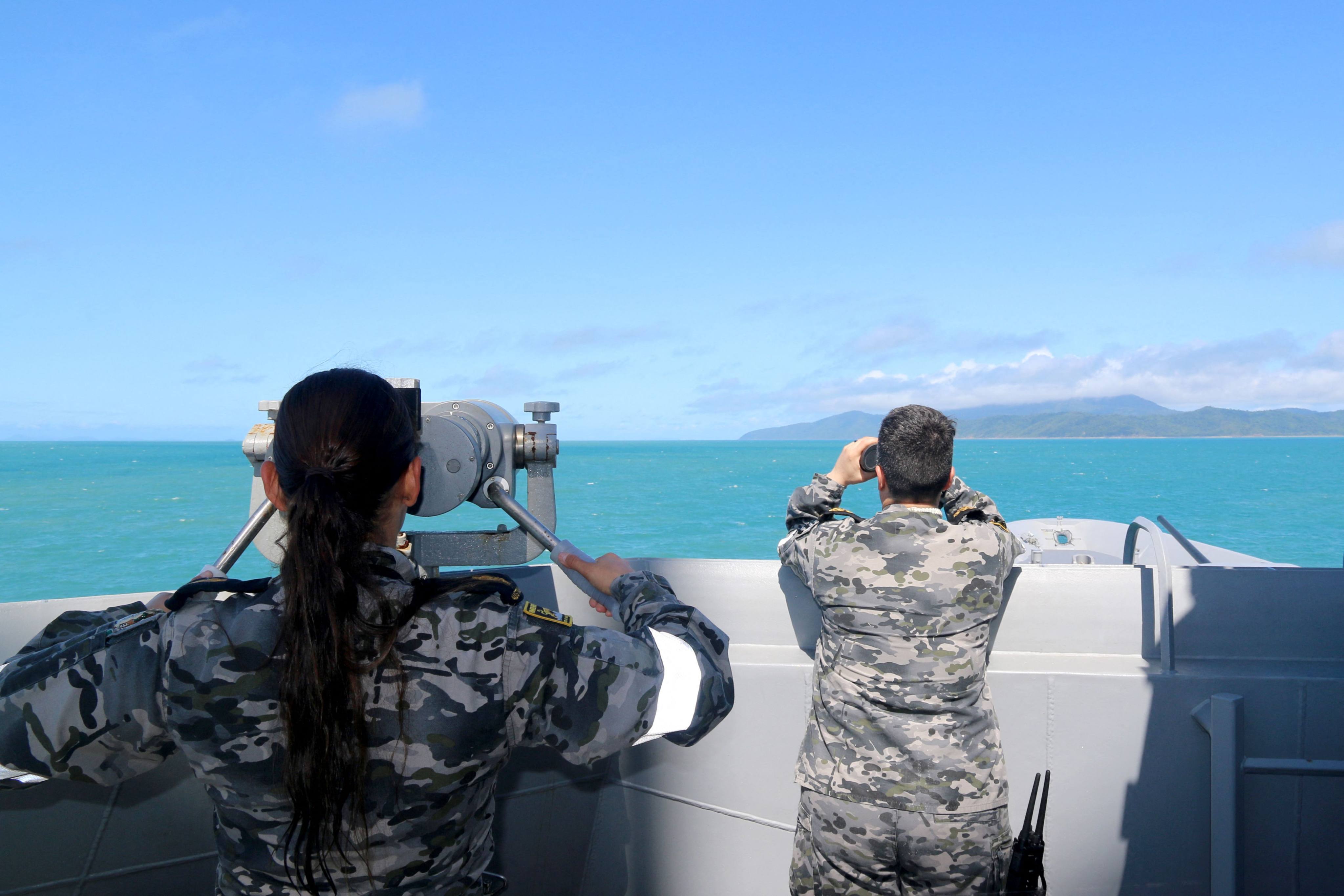 Australian sailors scan the ocean on Saturday for remnants of the crashed helicopter near Queensland’s Lindeman Island. Photo: Australian Defence Handout via AFP