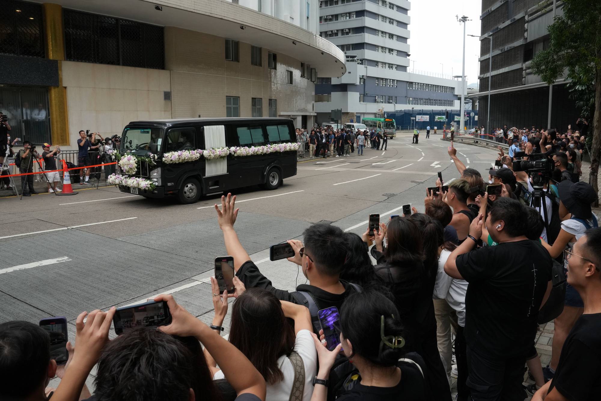 Coco Lee’s hearse leaves the funeral home as fans line the road. Photo: Elson Li