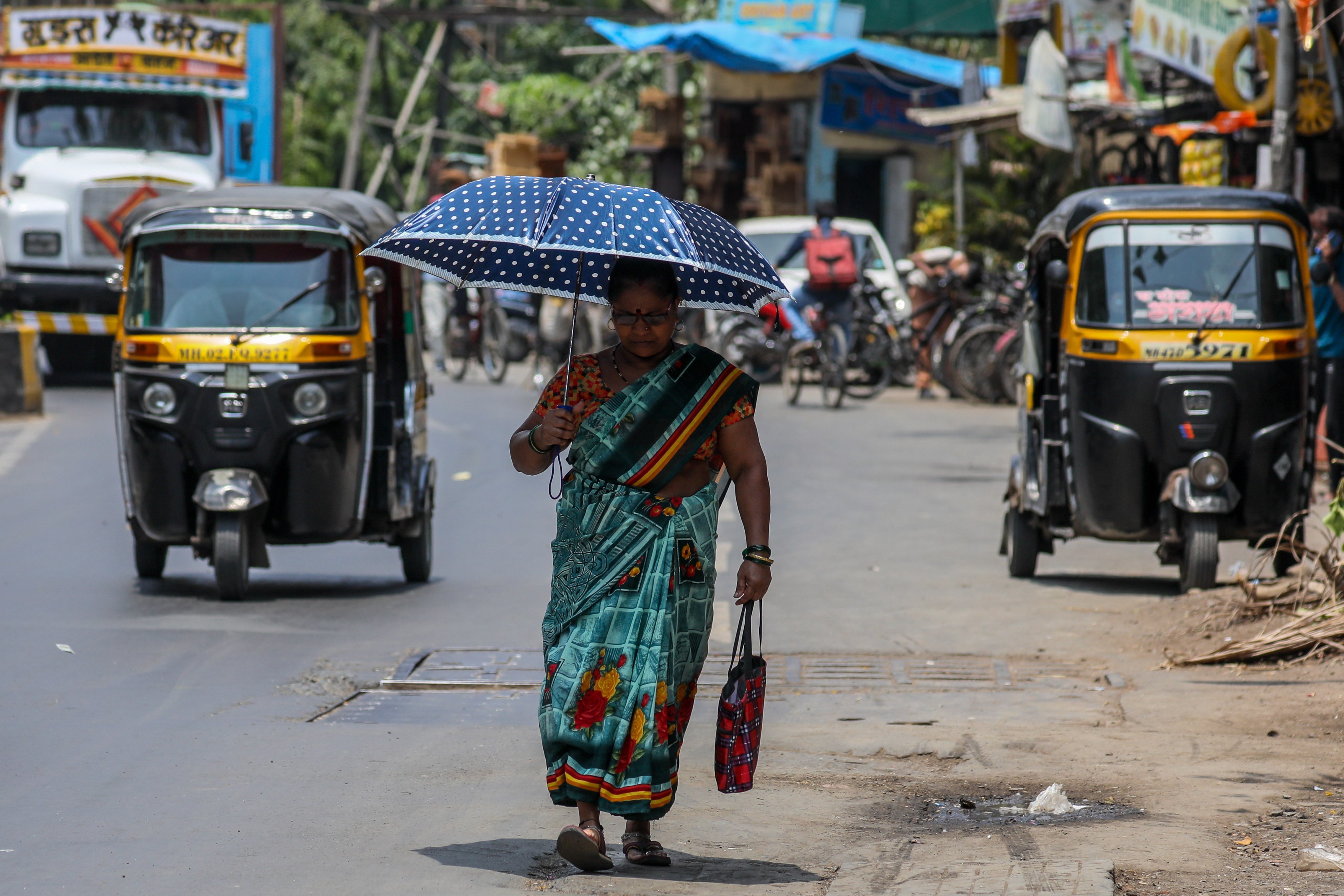 A woman walks with her umbrella to avoid the heatwave on a hot afternoon in Mumbai, India, in April 2023. Photo: EPA-EFE