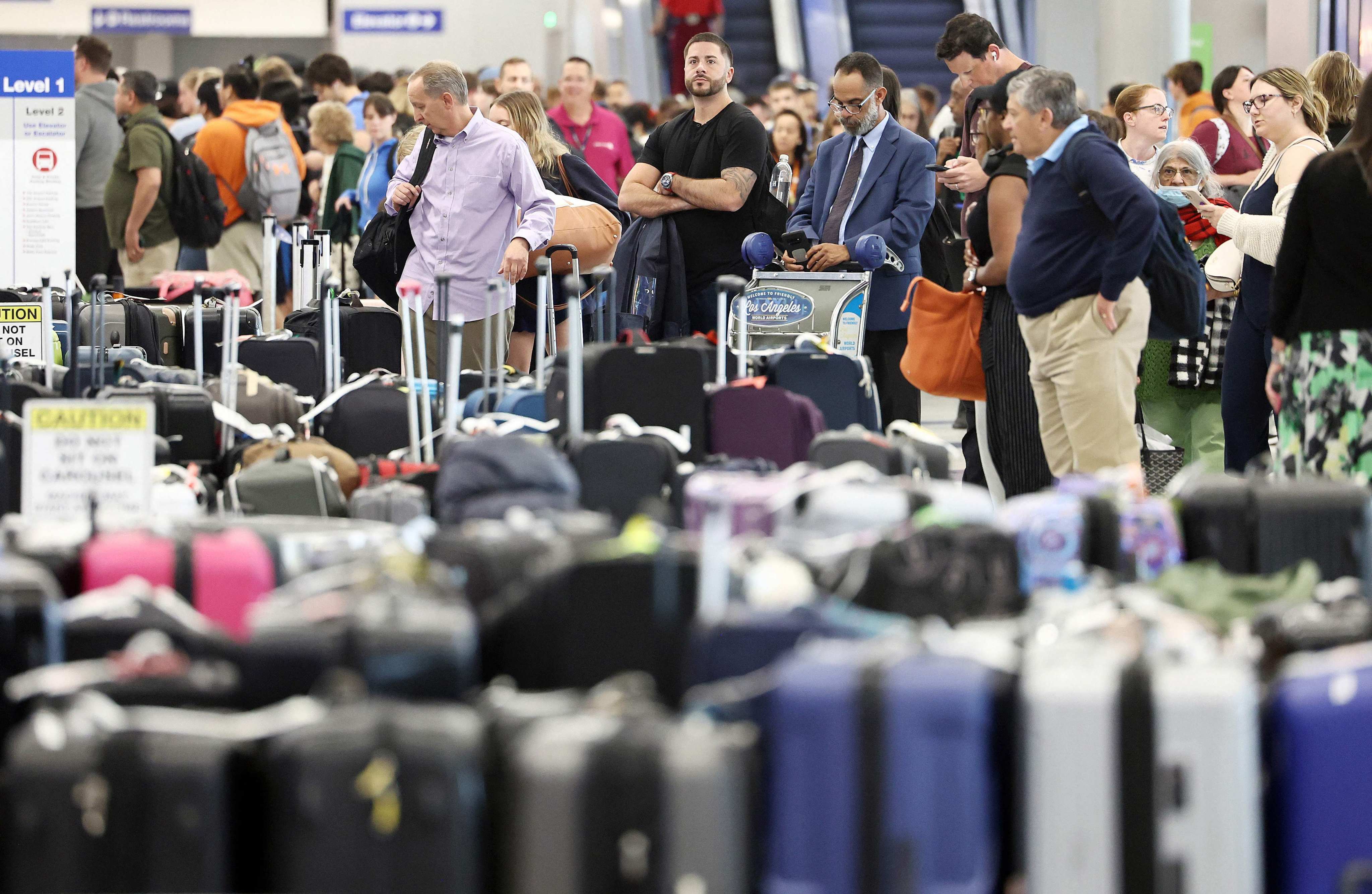 Travellers wait for their bags amid rows of unclaimed luggage at the United Airlines baggage claim area at Los Angeles airport on June 29, amid flight cancellations and delays. CEO Scott Kirby could have shown remorse by donating to a charitable fund in honour of affected United passengers and employees, or dedicating a pay cut to employees. Photo: Getty Images via AFP