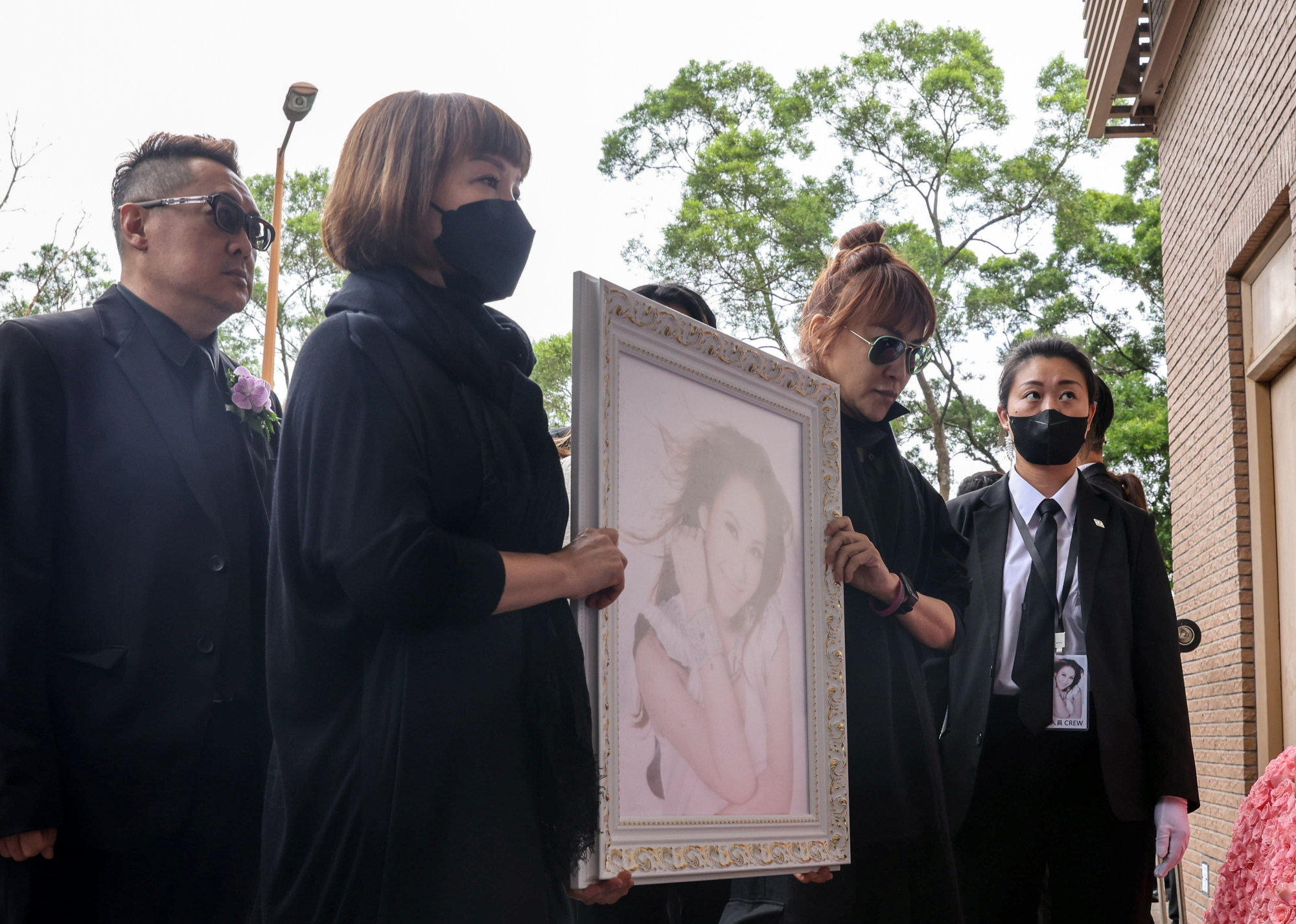 Lee’s sisters Carol and Nancy holding a portrait of the star. Photo: Yik Yeung-man