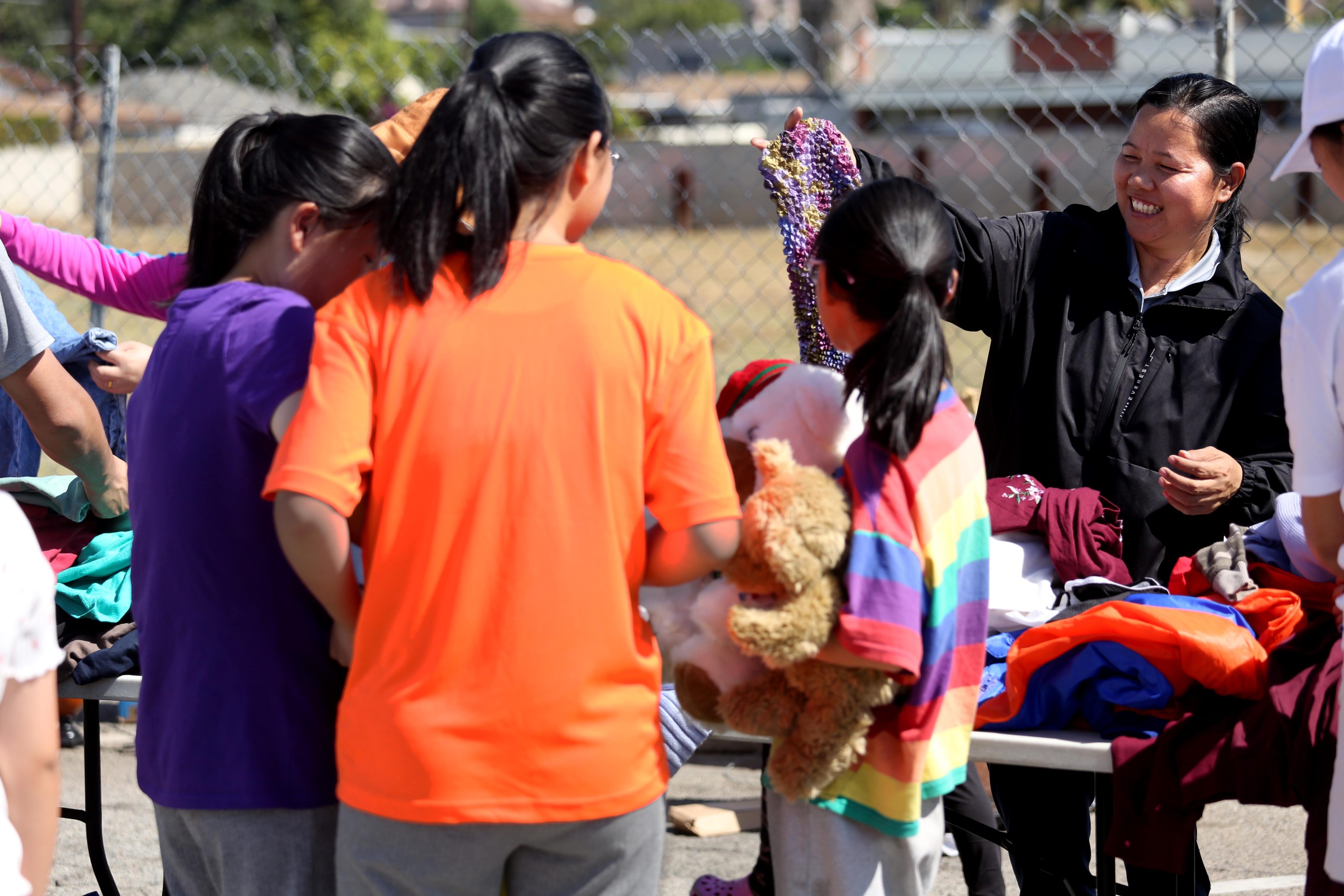 A woman who identified herself with the surname Dai, right, offers donated clothing to Chinese migrants at a giveaway event in Monterey Park in June. Photo: TNS