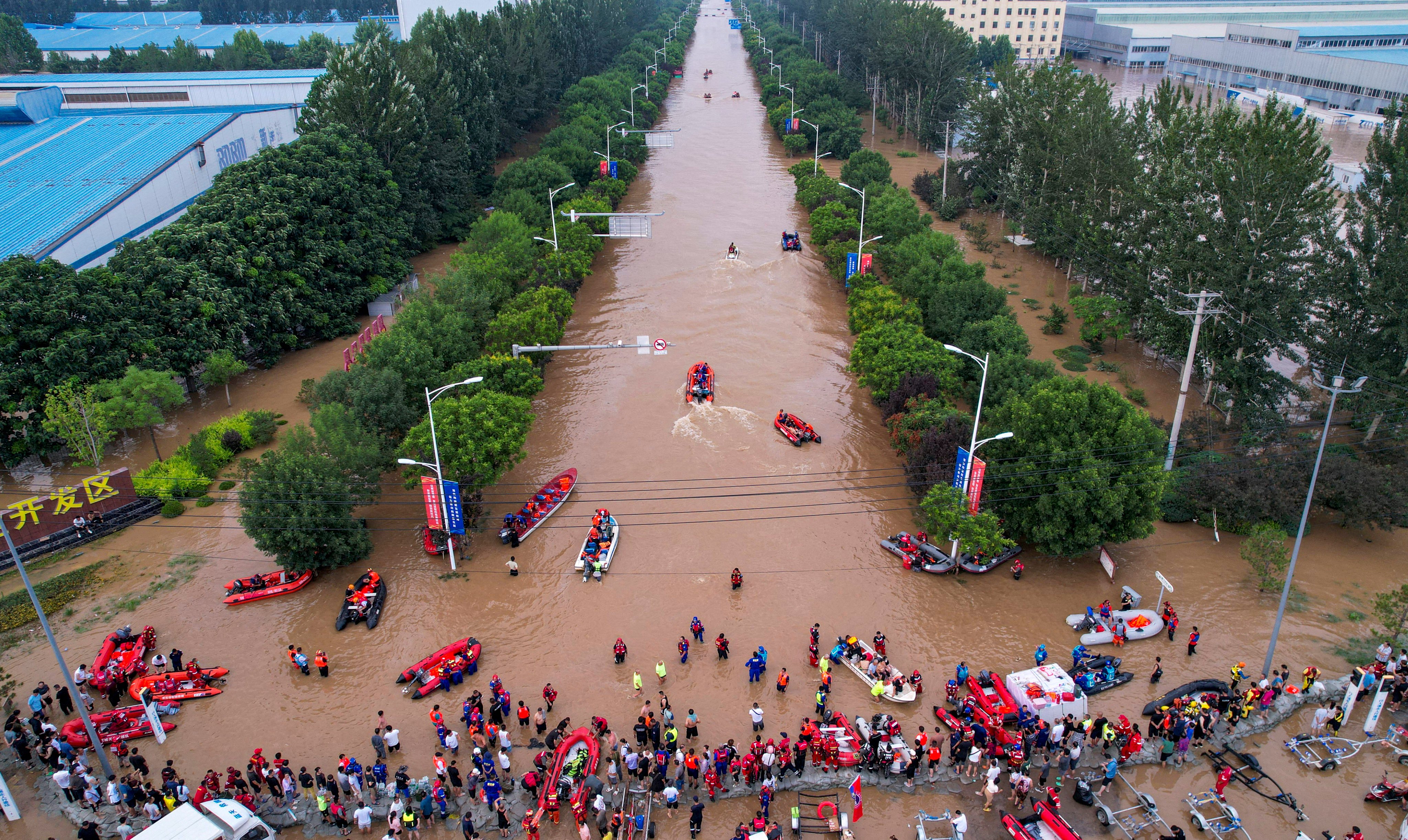 Rescue workers navigate a flooded road at an industrial development zone in Zhuozhou, Hebei province, on Wednesday. Photo: cnsphoto via Reuters