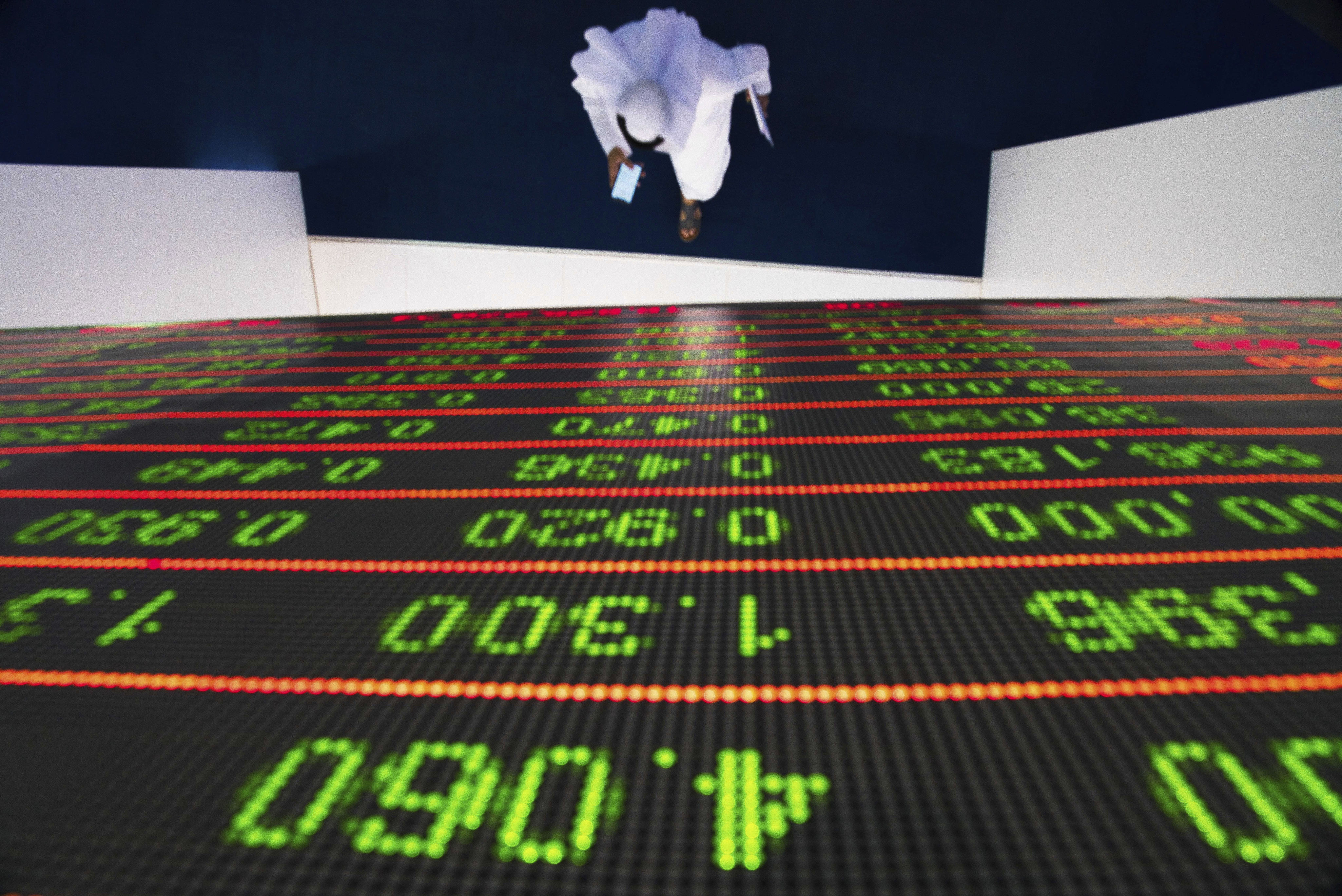 A man walks under the trading board at the Dubai stock exchange in October 2019. Dubai has a strong track record of attracting uber-rich investors, in particular from India, and recently also from Russia. Photo: AP