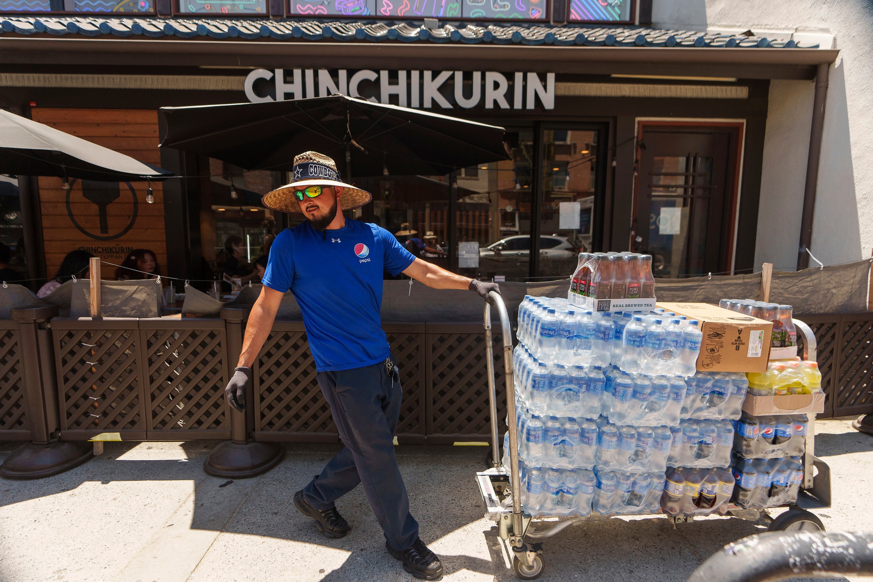 A man delivers drinks in the Little Tokyo district of Los Angeles on July 27. The US labour market has added jobs at a steady clip in the past year despite efforts by the Federal Reserve to cool the economy, raising both optimism among investors for the prospects of a soft landing and concern among analysts that the fight against inflation will continue. Photo: AP