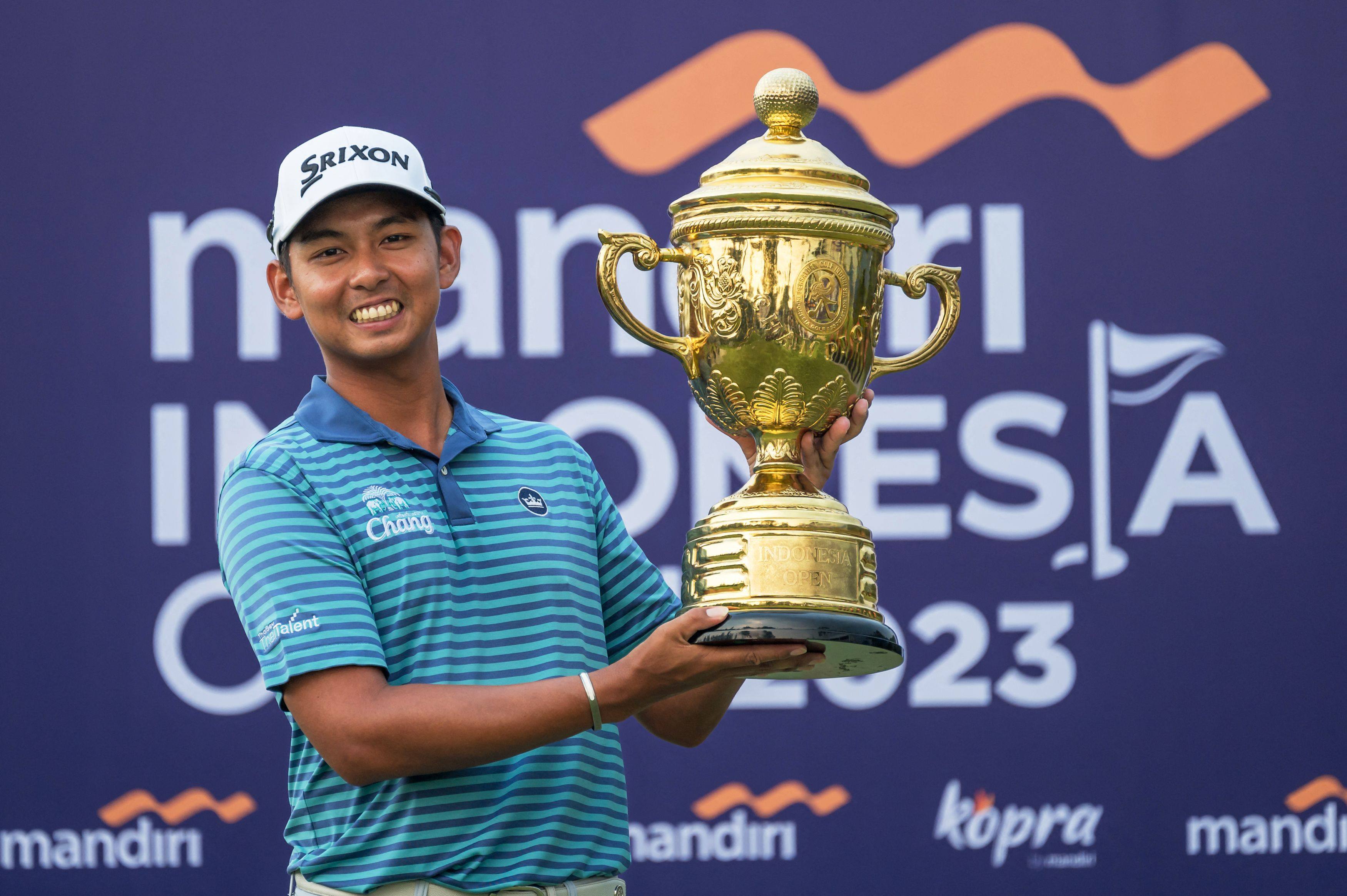 Nitithorn Thippong poses with the Mandiri Indonesia Open trophy after his two-stroke vctory in Jakarta. Photo: AFP