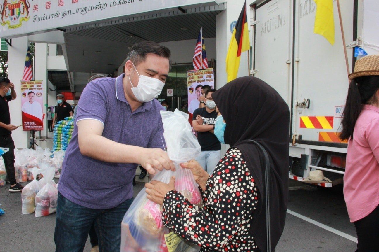 DAP’s Anthony Loke hands out a food pack to a Malaysian resident. Photo: Facebook