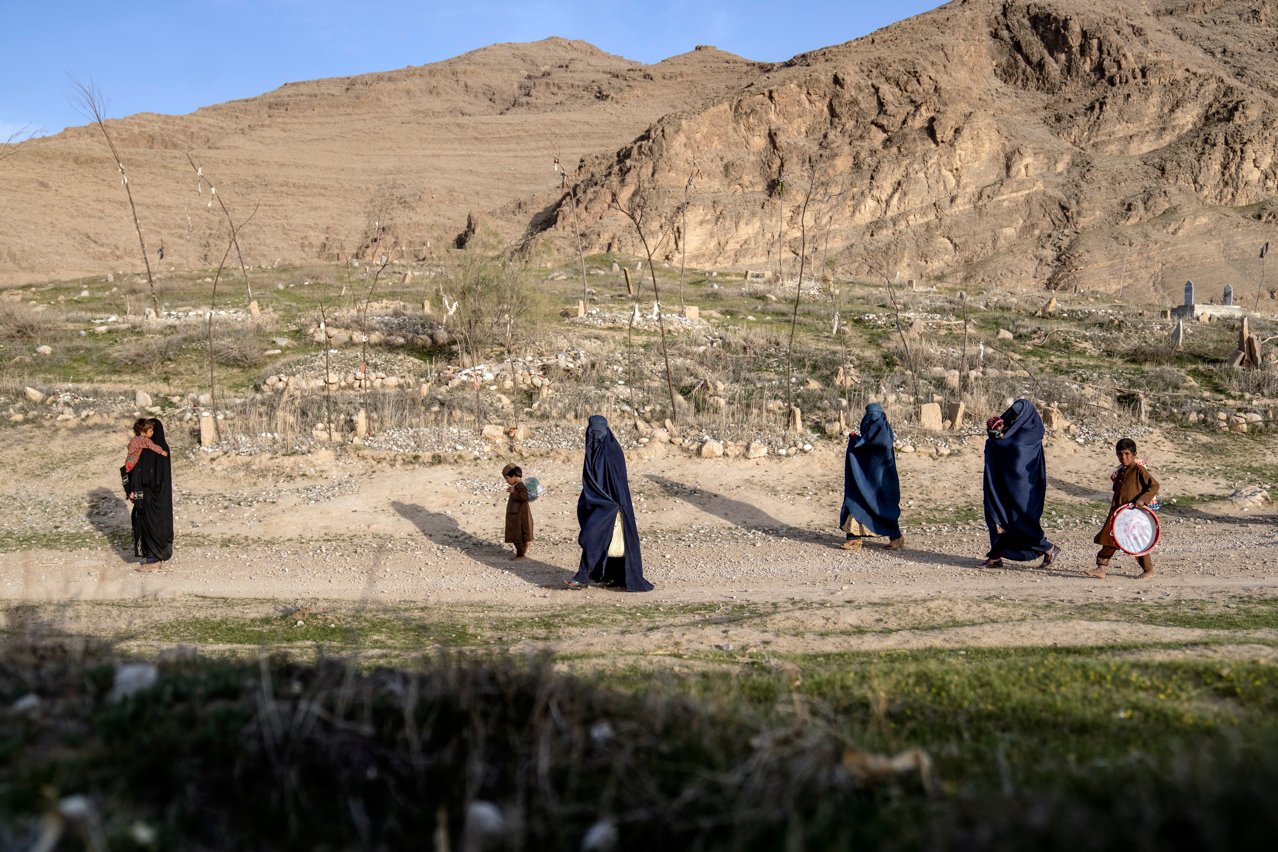 Women walk through a cemetery in a village in a remote region of Afghanistan. The Taliban administration has barred girls from high schools, universities and most jobs, including working for the UN and NGOs. Photo: AP