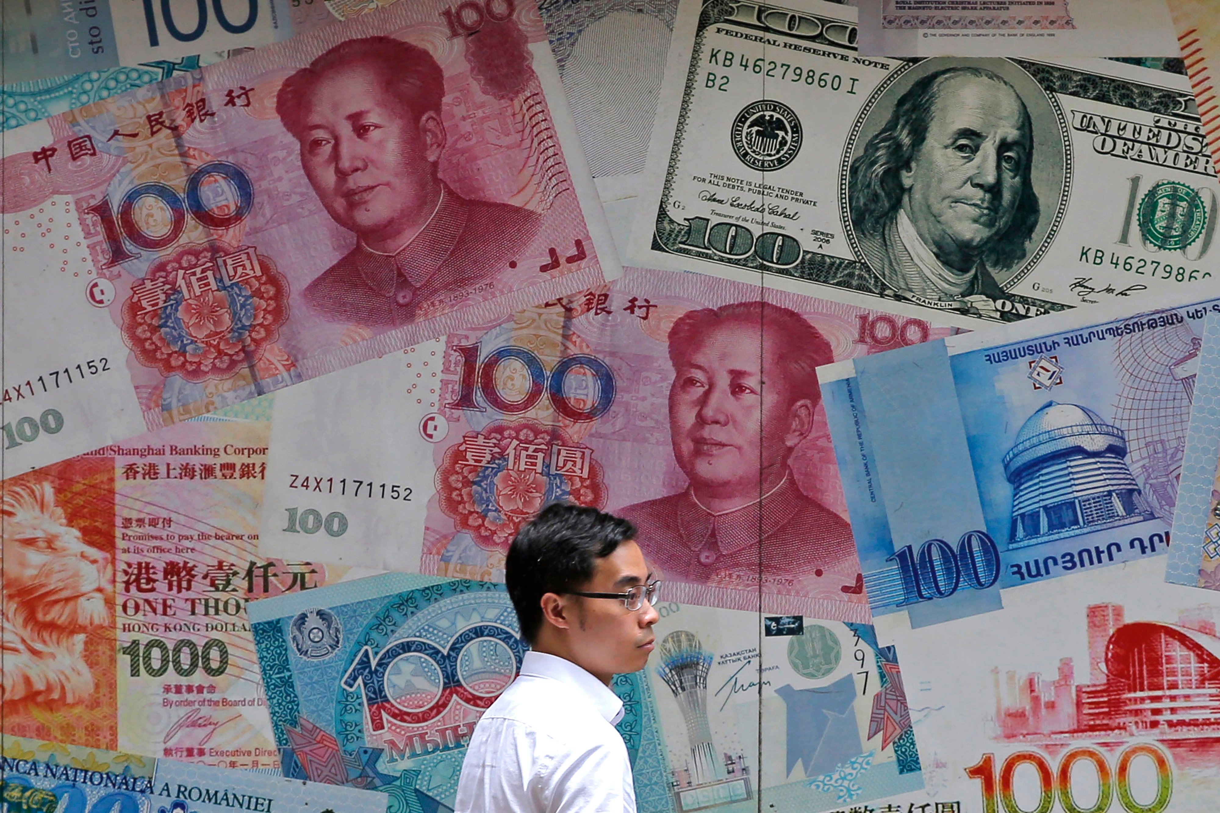 A man walks past a money exchange shop decorated with different banknotes at Central, a business district of Hong Kong. Photo: AP