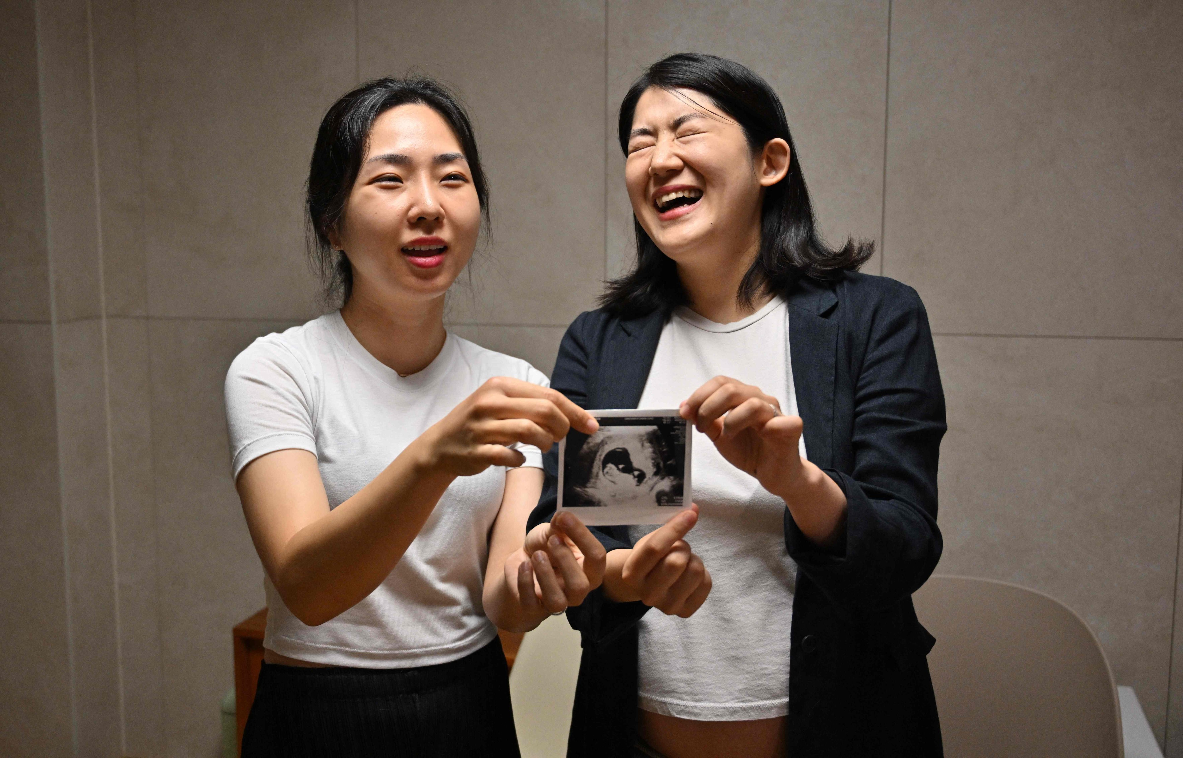 South Korean lesbian couple Kim Kyu-jin (right) and wife Kim Sae-yeon pose with a fetal ultrasound image. South Korea does not recognise same-sex unions. Photo: AFP