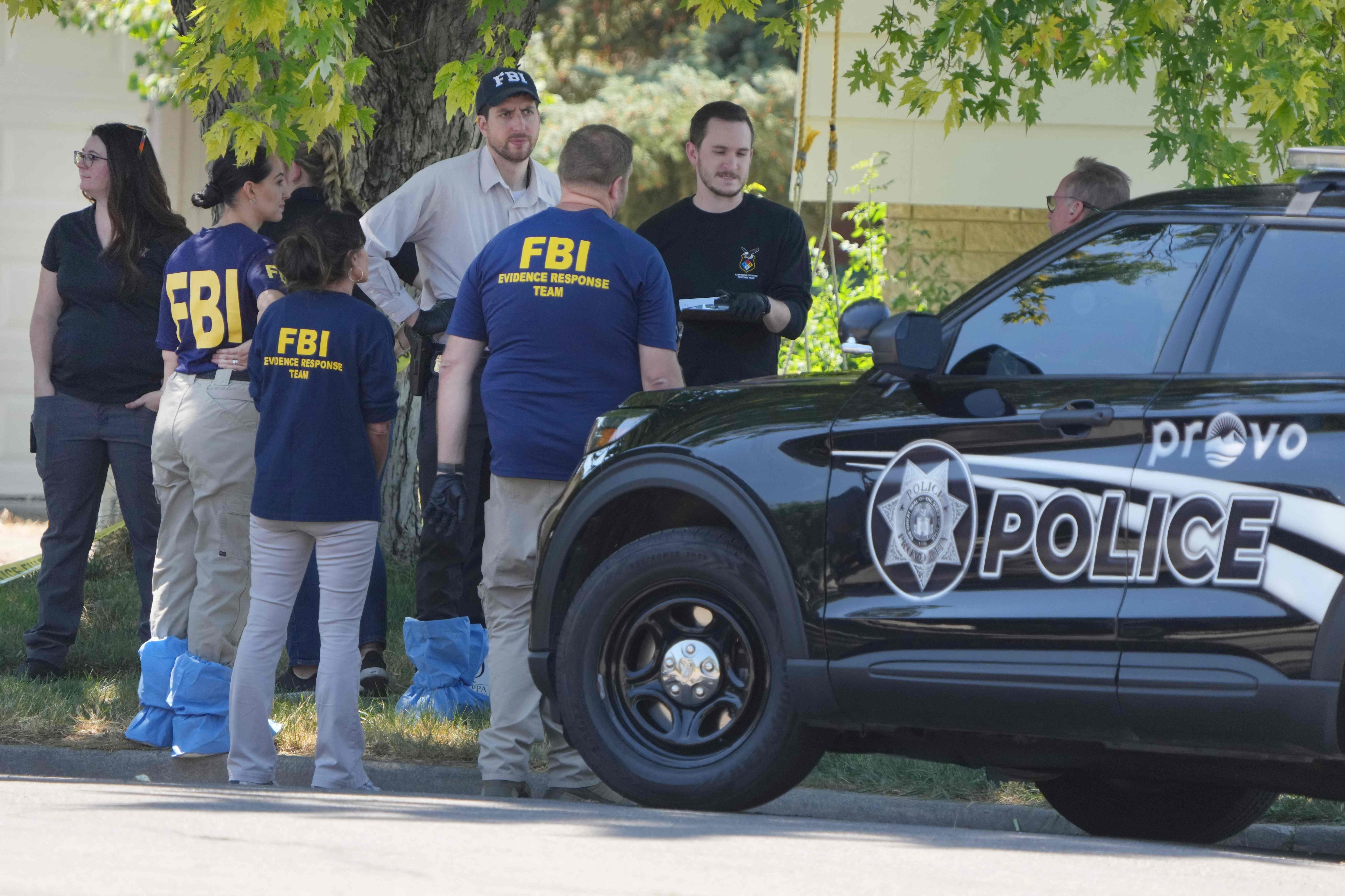 FBI officials and other law enforcement officers stand outside the home of Craig Robertson. who was shot and killed in a raid on his home in Provo, Utah, on Wednesday. Photo: AFP