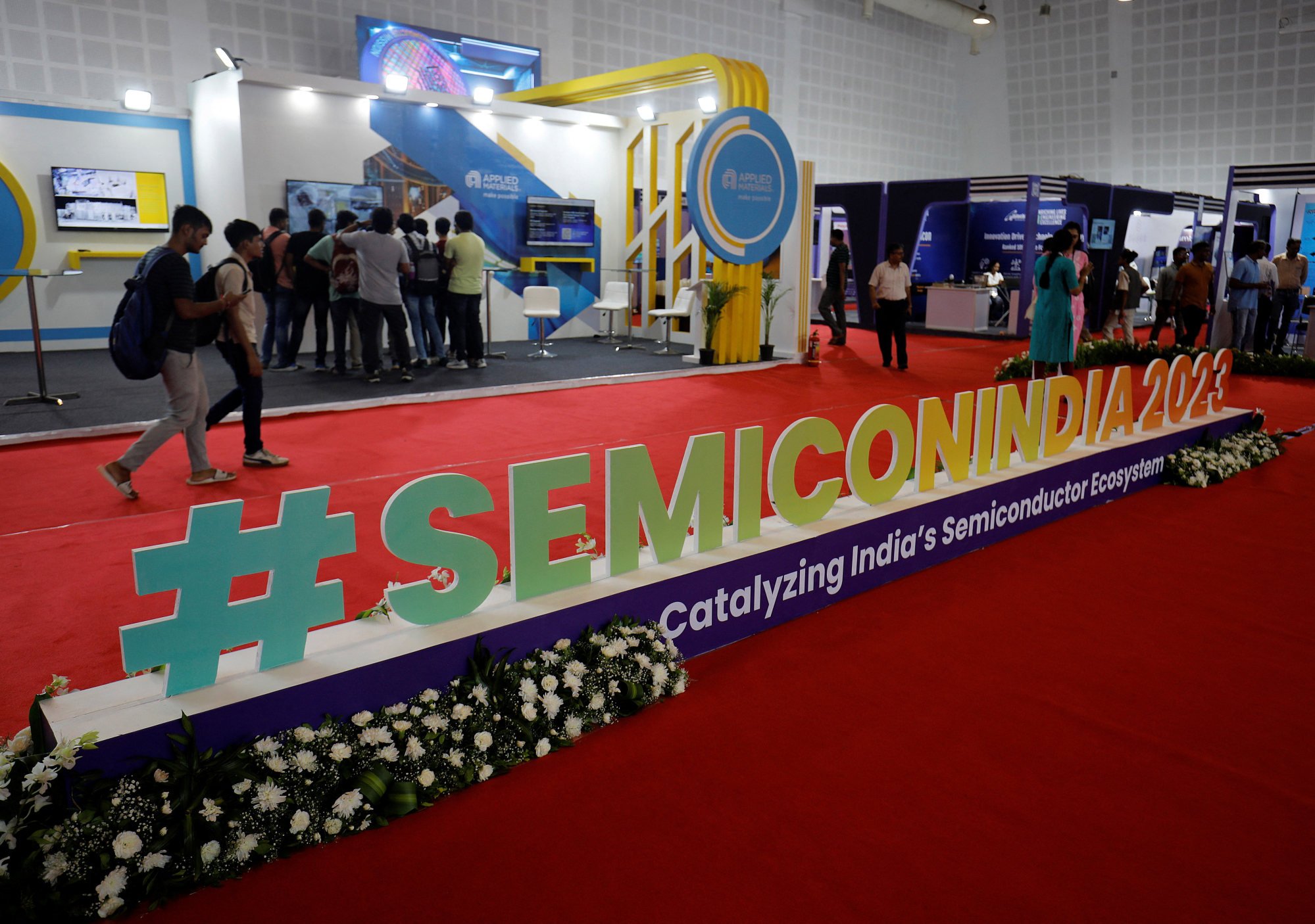 Visitors gather at the Applied Materials and Micron Technology kiosks before the start of SemiconIndia 2023, India’s annual semiconductor conference, in Gandhinagar, India, on July 25. Photo: Reuters