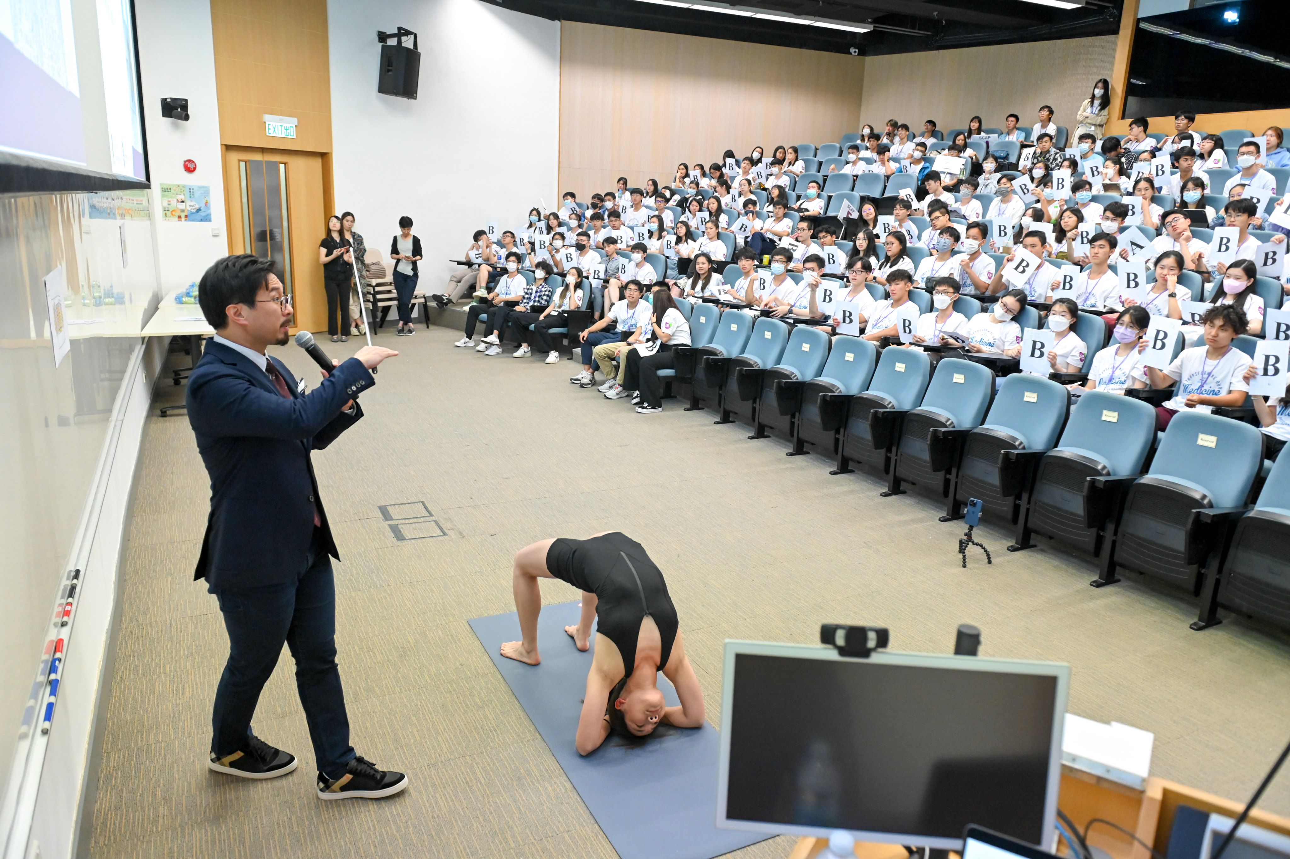 Dr Christopher See Yew-hong presents a unique anatomy lesson as junior research assistant Charlotte Lin Tien-lan holds a back-bending wheel pose. Photo: CUHK