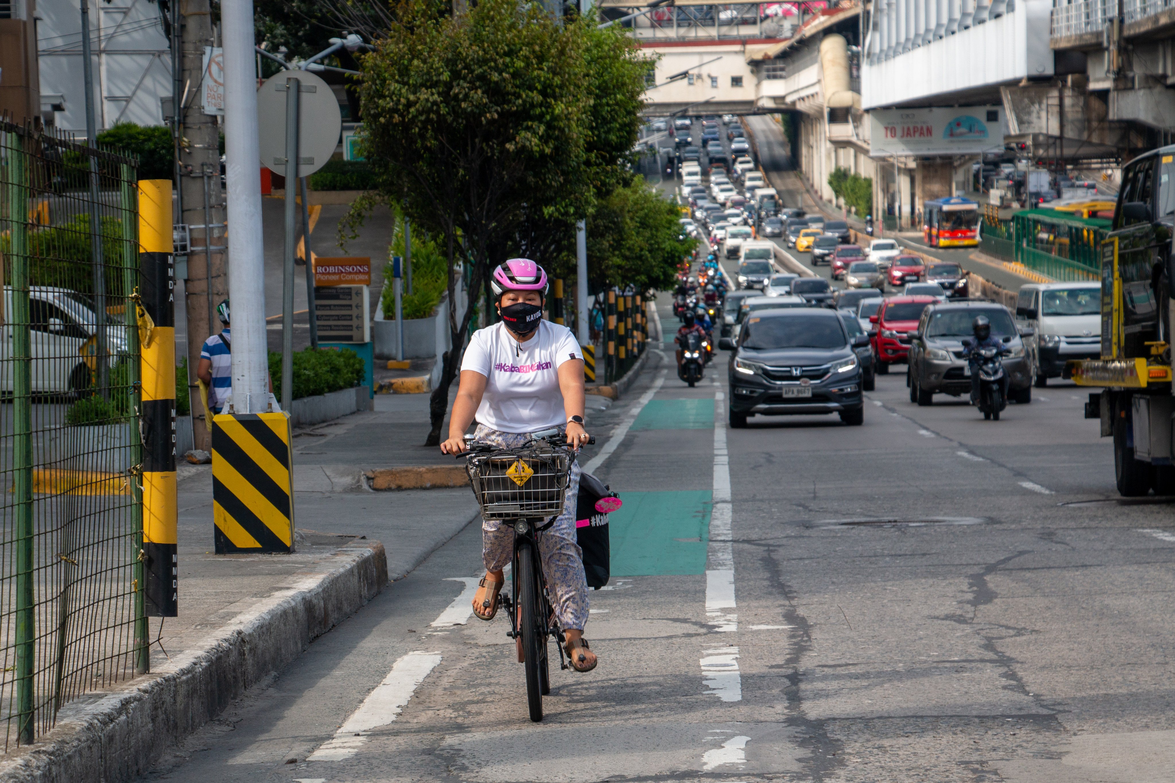 Jaramia Amarnani, 41, braves unfriendly drivers and motorcycle-filled bike lanes in the Metro Manila area. She has a sign on the back of her bike saying ‘Working Mom, Pass With Care’. Photo: Jhesset O. Enano