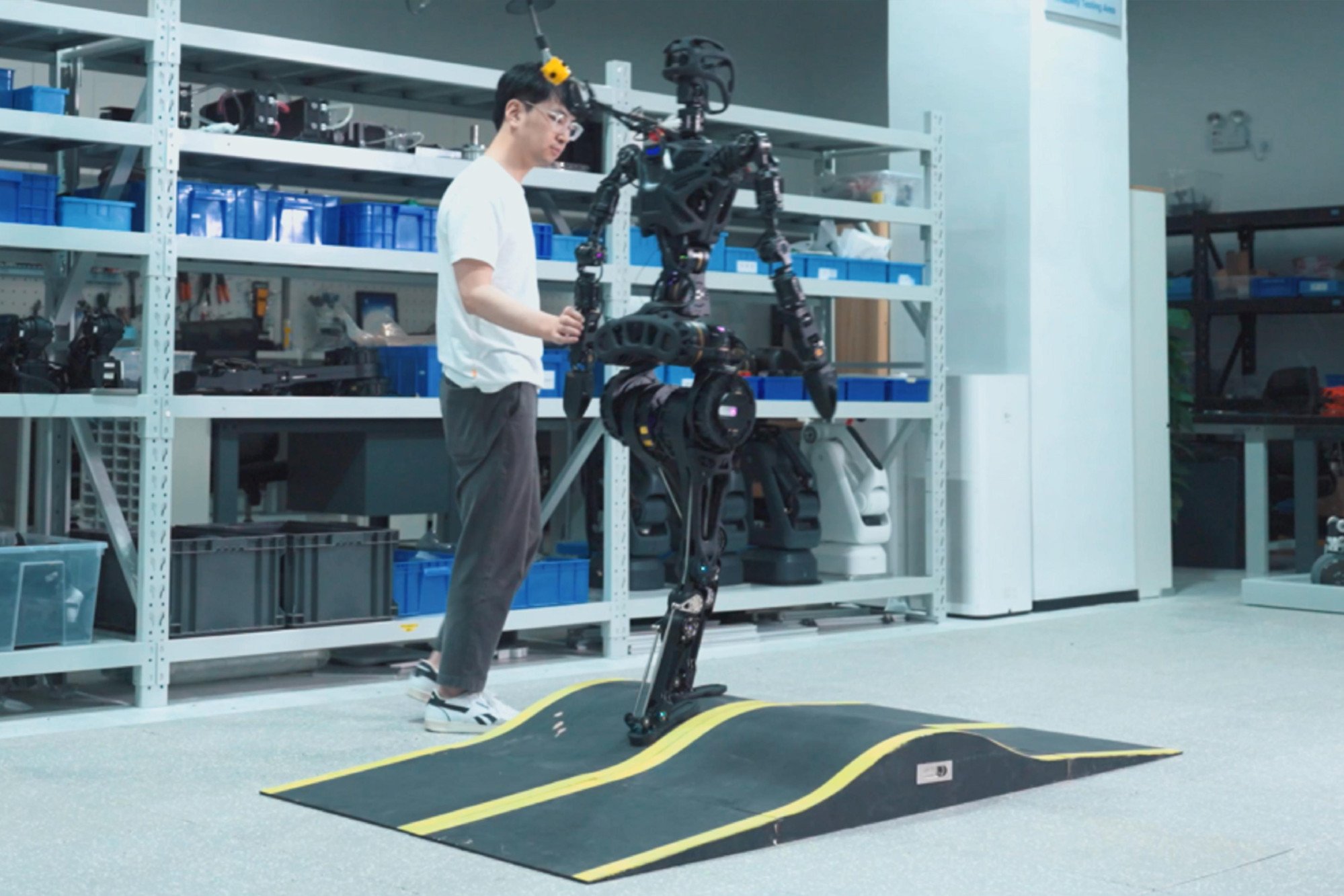 A Fourier Intelligence engineer tests the self-balancing ability of the company’s humanoid robot. Photo: Handout