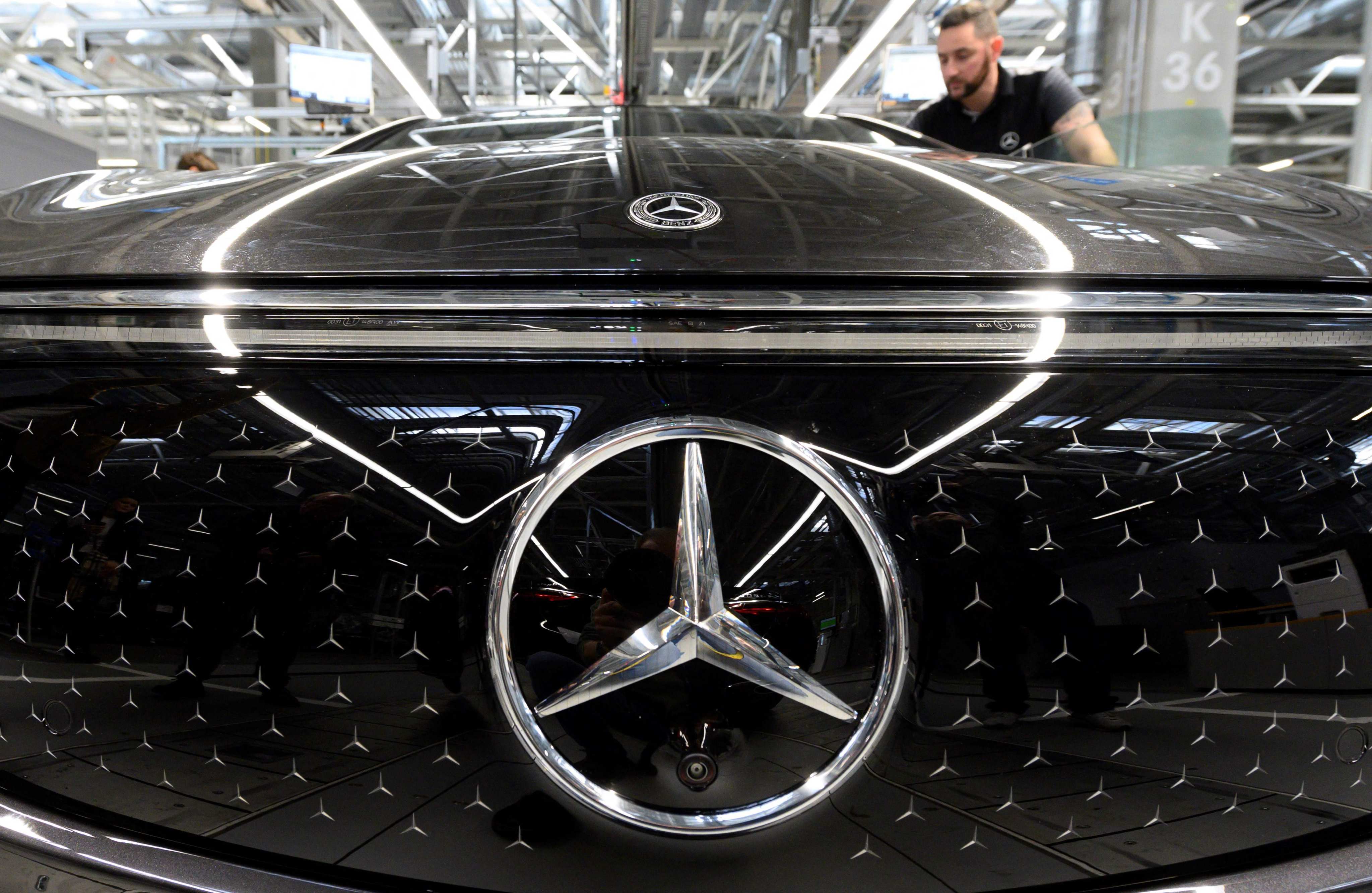 A worker inspects an all-electric EQS passenger car on an assembly line at a Mercedes-Benz manufacturing plant in Germany earlier this year. Photo: AFP