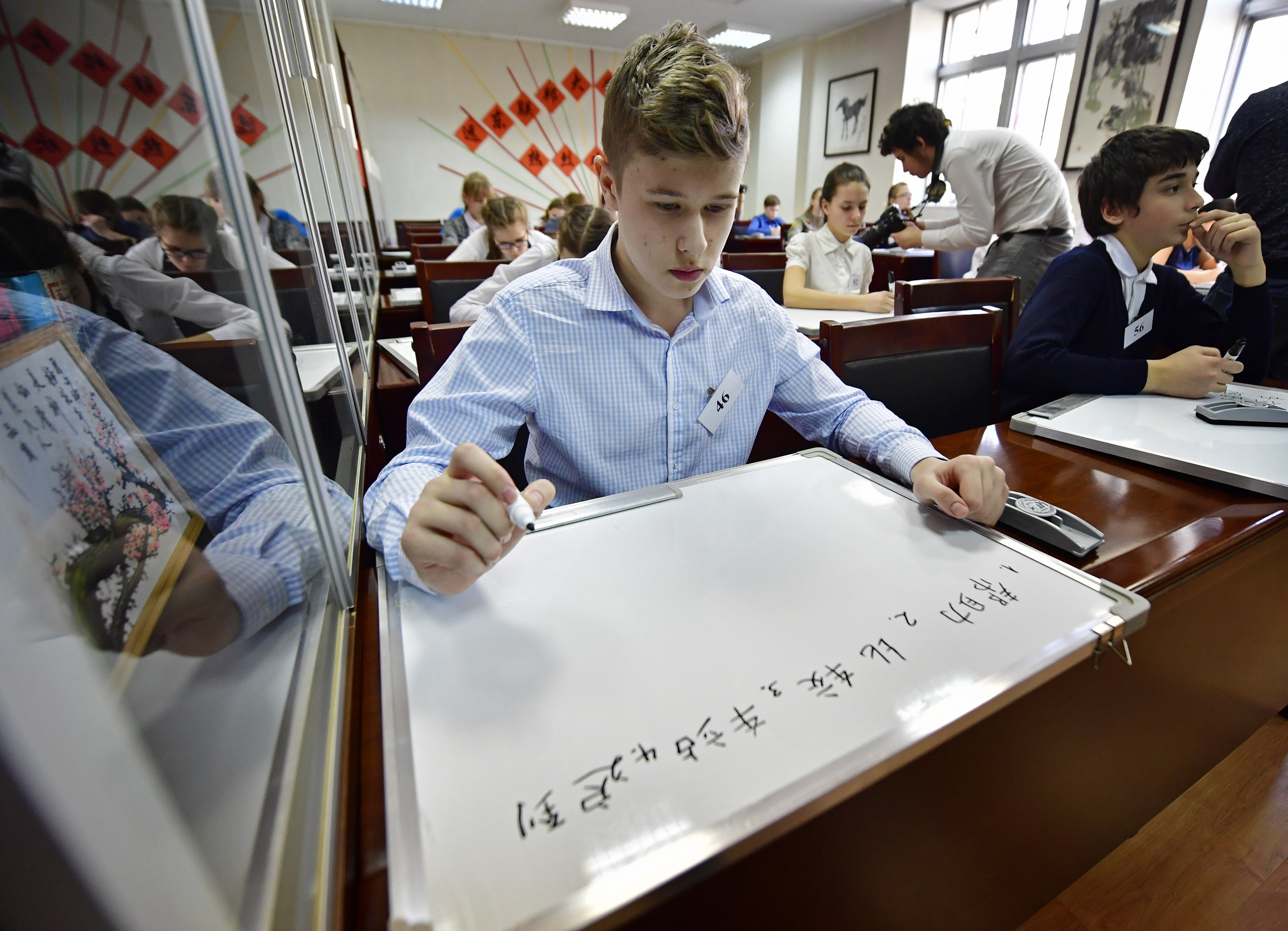 Students write Chinese characters on whiteboards at a dictation contest at the Confucius Institute at Far Eastern Federal University in Vladivostok, Russia, on February 8, 2017. Photo: TASS via Getty Images