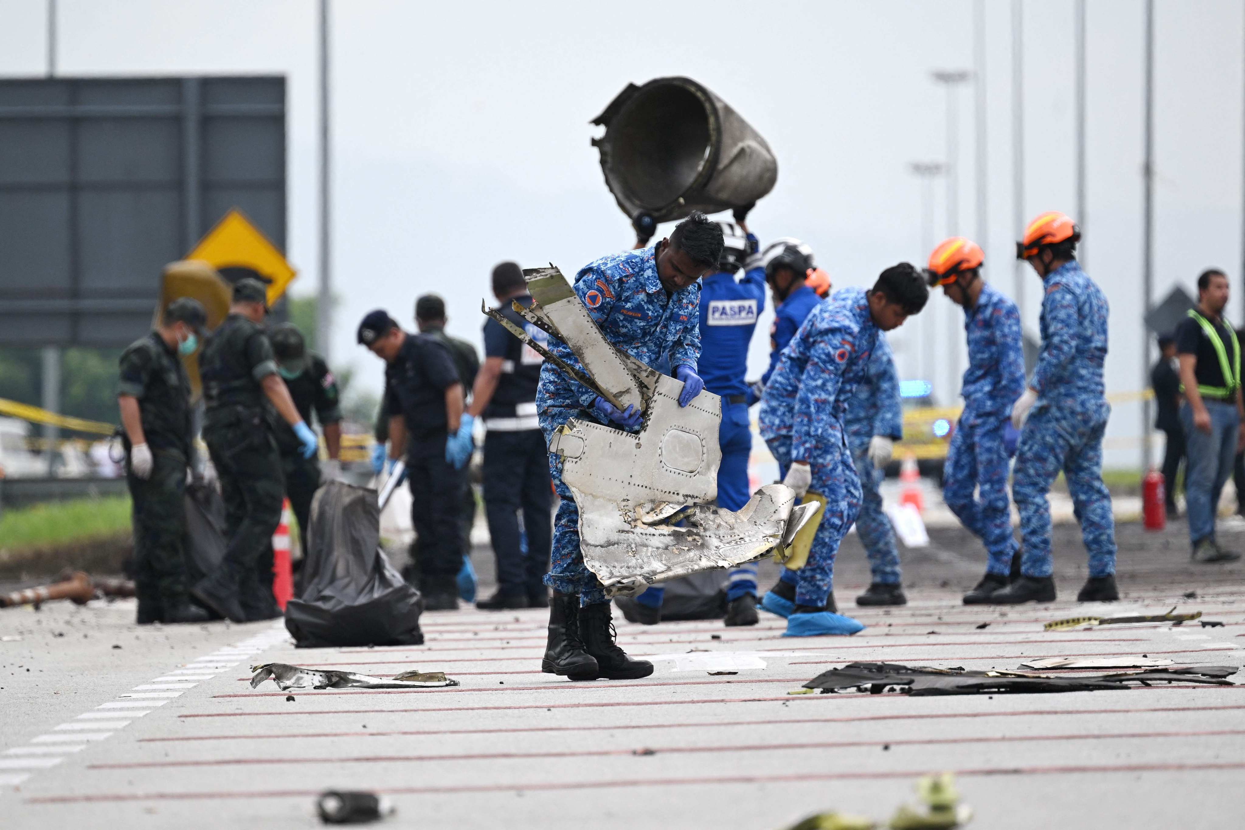 Rescuers collect debris at the plane crash site in Selangor, Malaysia, on Friday. Photo: AFP
