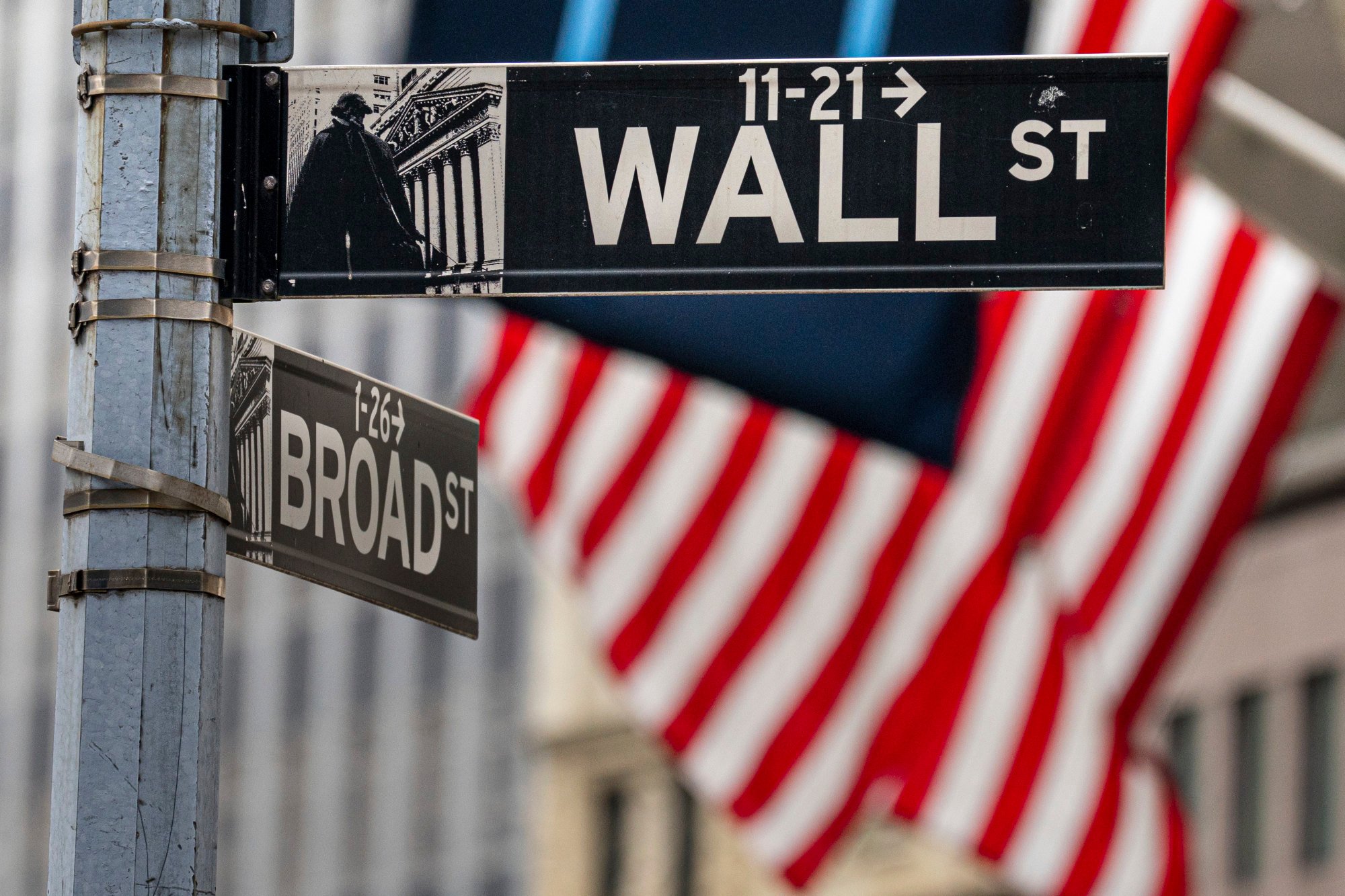 Street signs at the centre of the New York City financial district frame US flags flying from the front of the New York Stock Exchange on August 16. Photo: AP