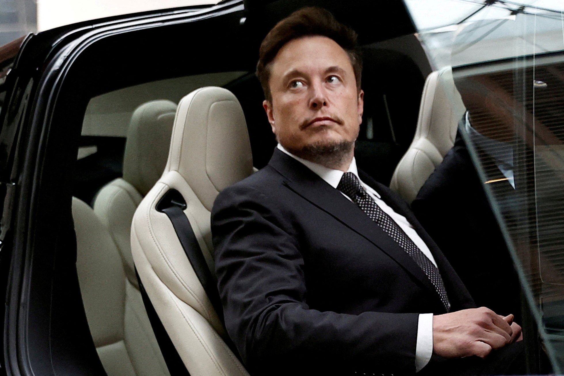 Tesla CEO Elon Musk emerges from one of his company’s electric vehicles outside a hotel in Beijing, China in May 2023. Photo: Reuters