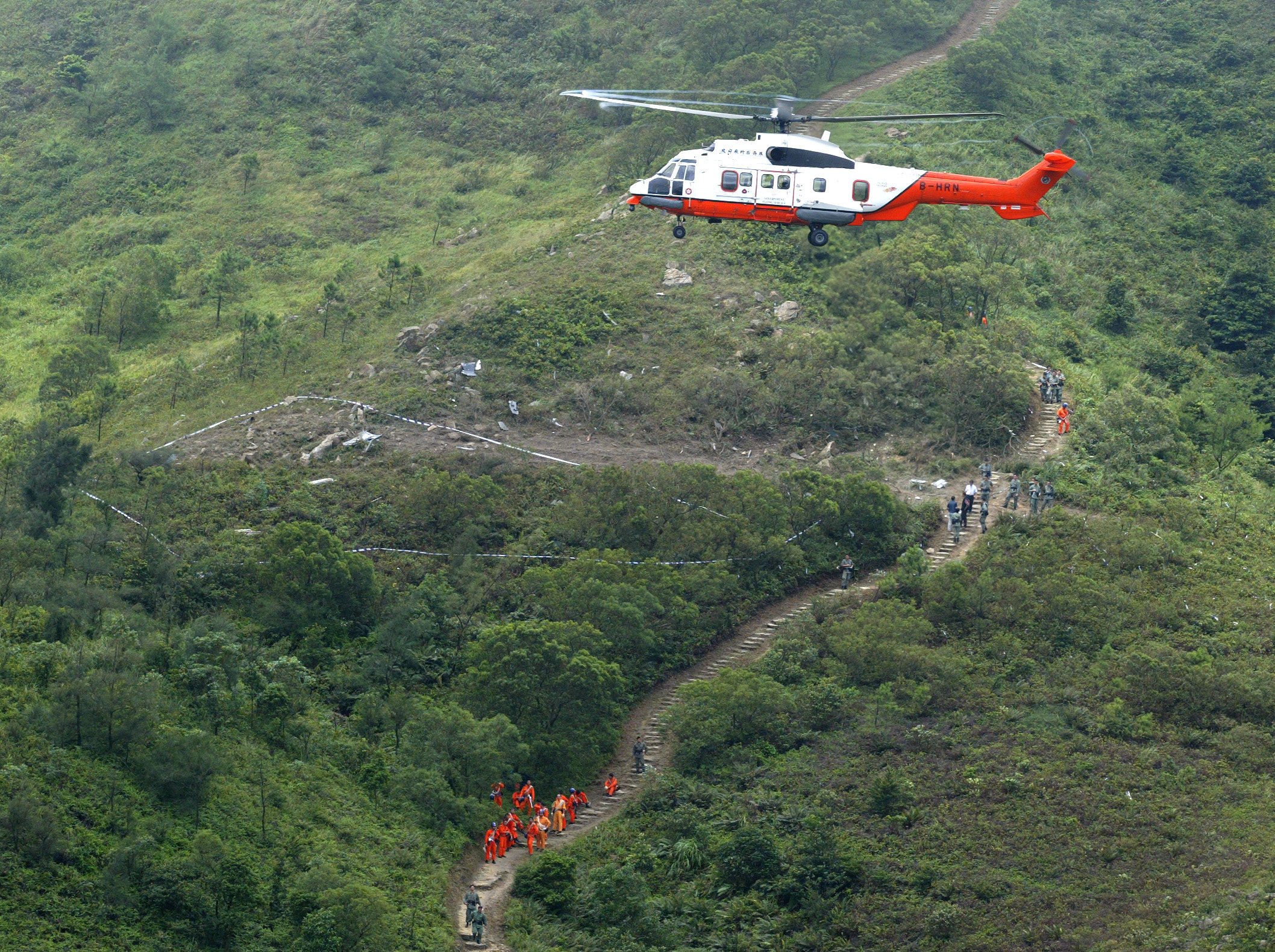 A Government Flying Service helicopter hovers over the site on Lantau Island, Hong Kong, where another GFS helicopter crashed in 2003, killing both crew. Photo: SCMP