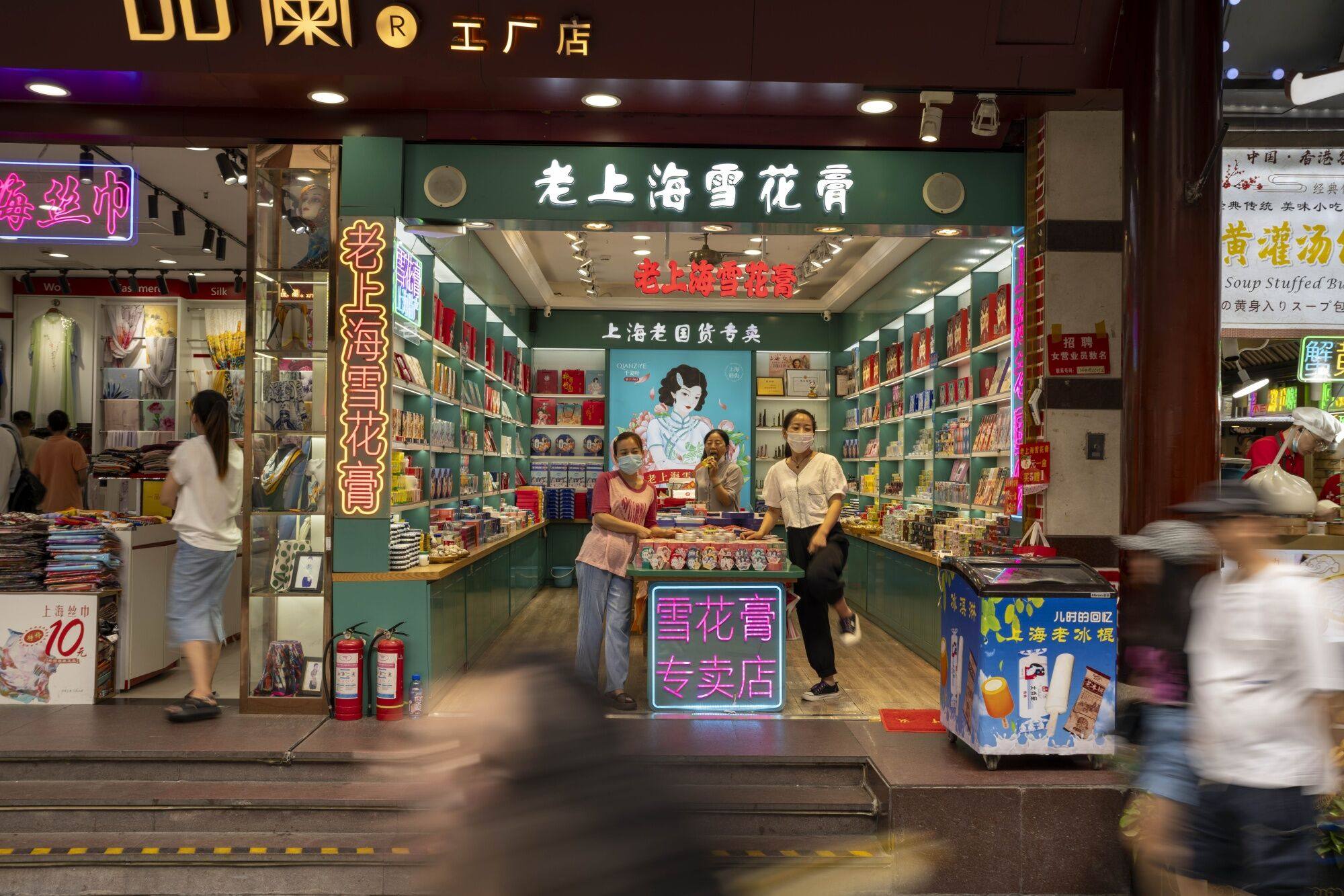 Salespeople wait for customers in a store in Shanghai. Photo: Bloomberg