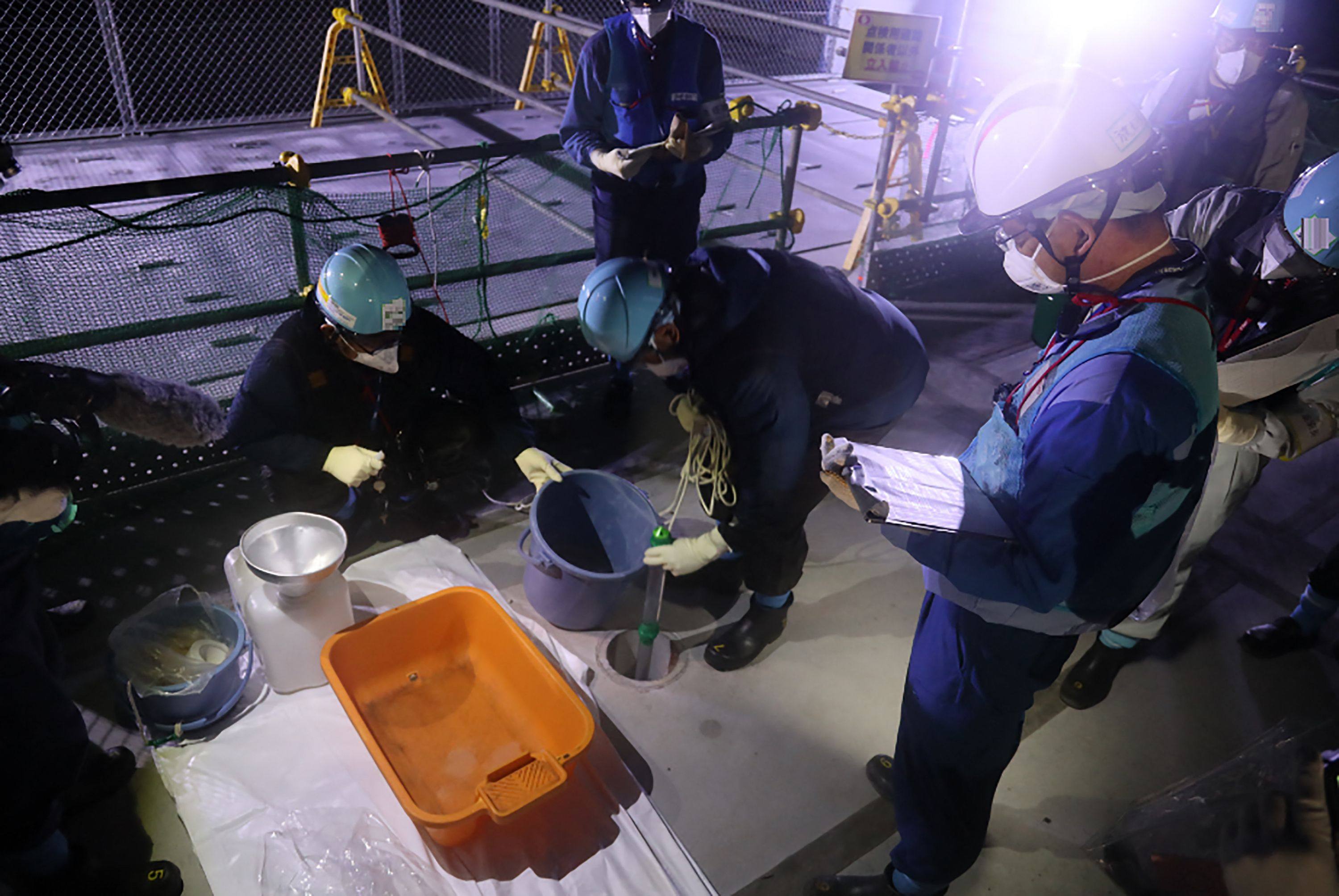 Tepco employees sample treated waste water at the Fukushima Daiichi nuclear power plant on Tuesday ahead of the planned start of its release into the Pacific Ocean. Photo: Tepco Handout via AFP