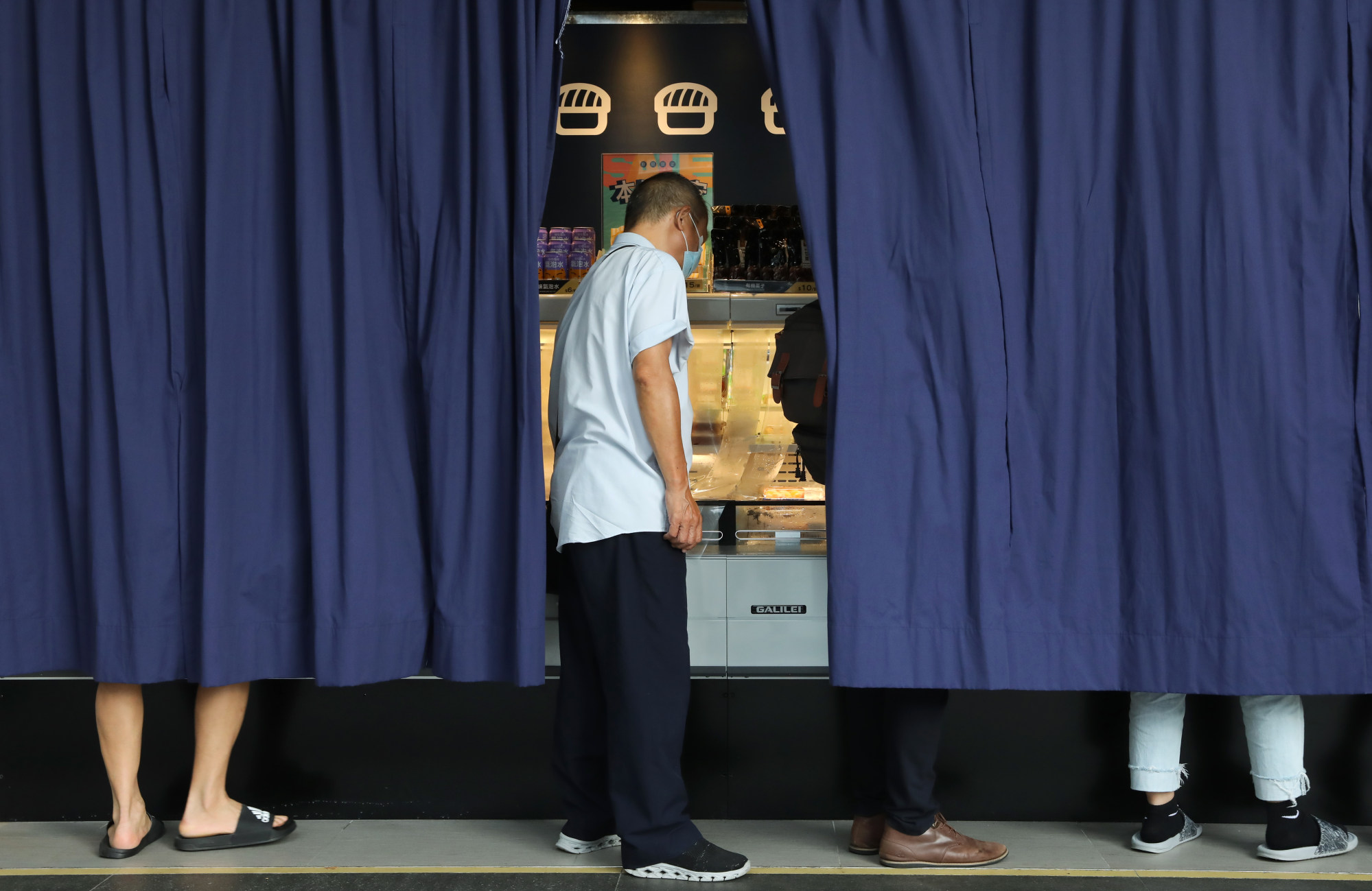 Hongkongers selecting sushi takeaway boxes behind a curtain at an outlet in Tung Chung. Food safety measures sparked by the waste water discharge plan will be in place Thursday. Photo: K. Y. Cheng