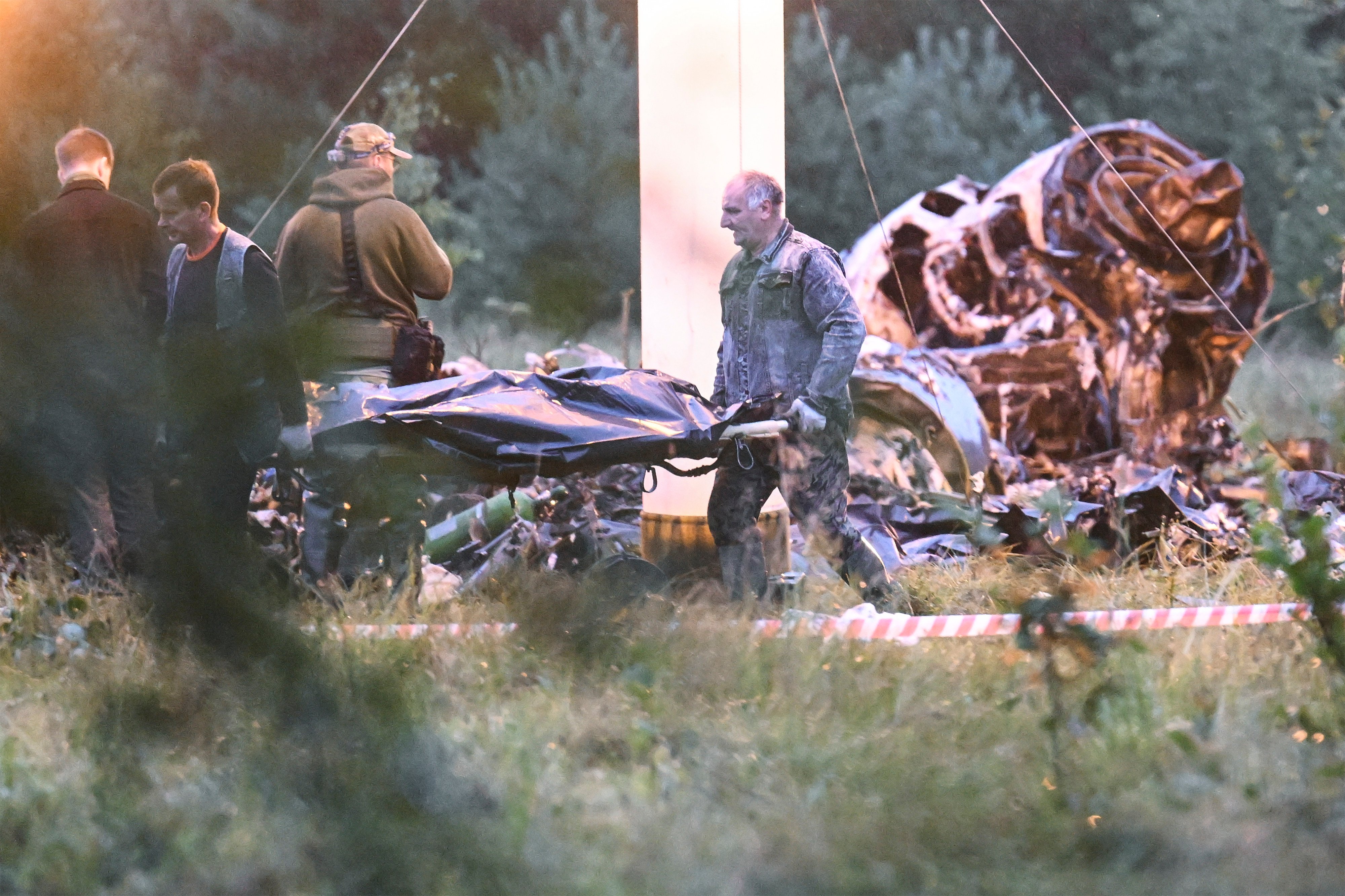 People carry a body bag away from the wreckage of the crashed jet. Photo: AP