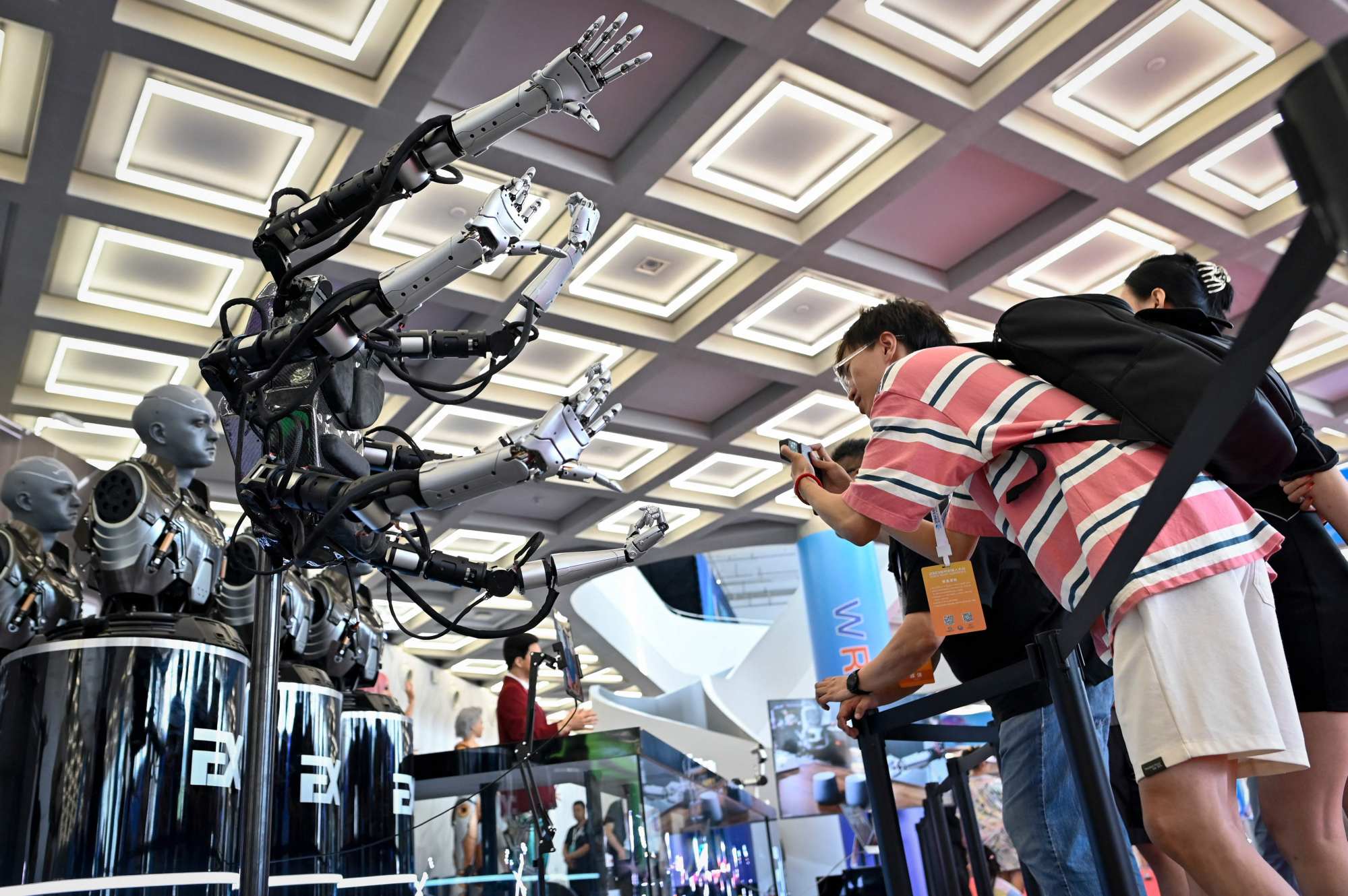 Visitors take pictures of robot arms at the 2023 World Robot Conference in Beijing on August 16. Photo: AFP