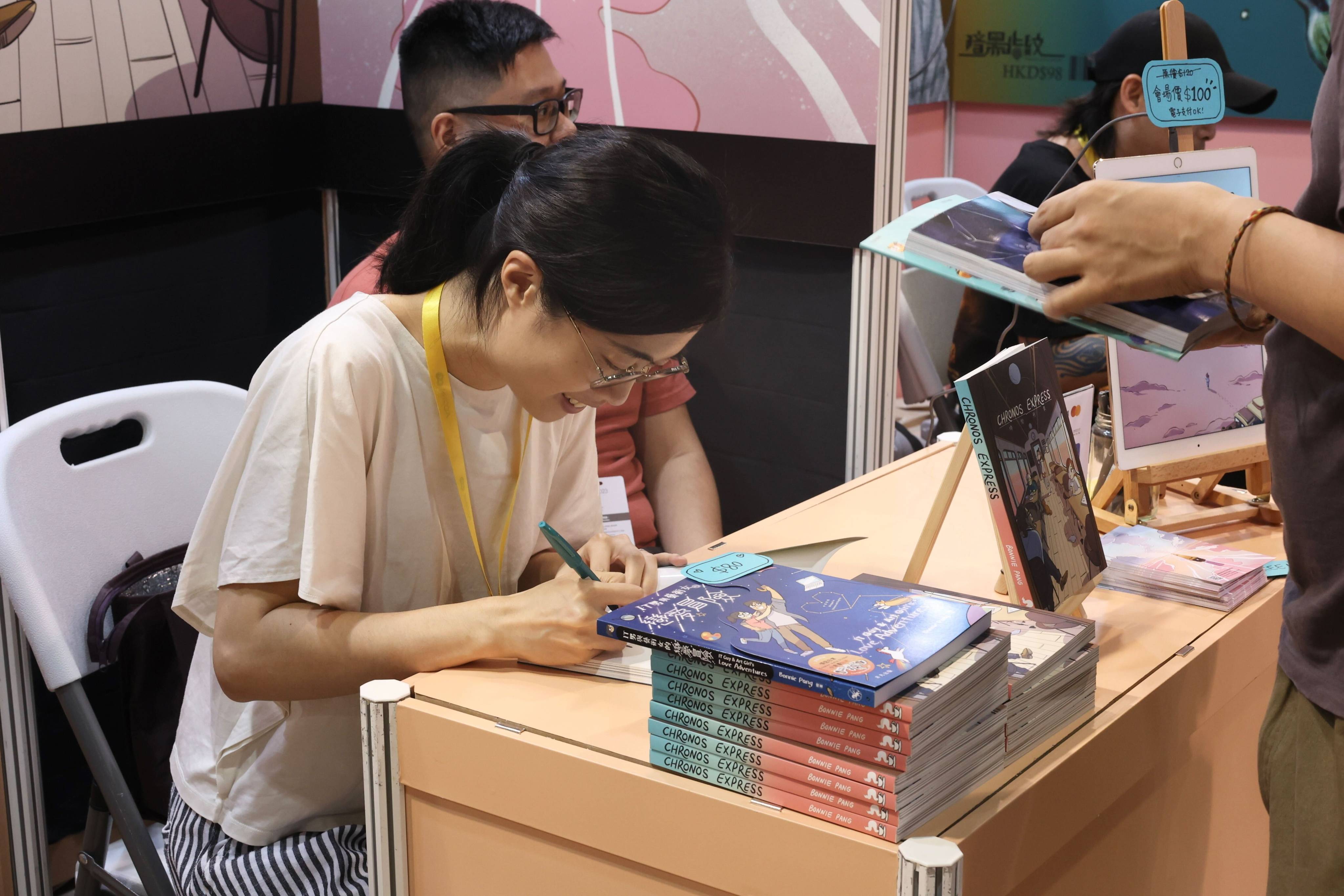 Bonnie Pang signs a copy of her new book for a fan at Ani-com & Games Hong Kong. Photo: Andee Capellan