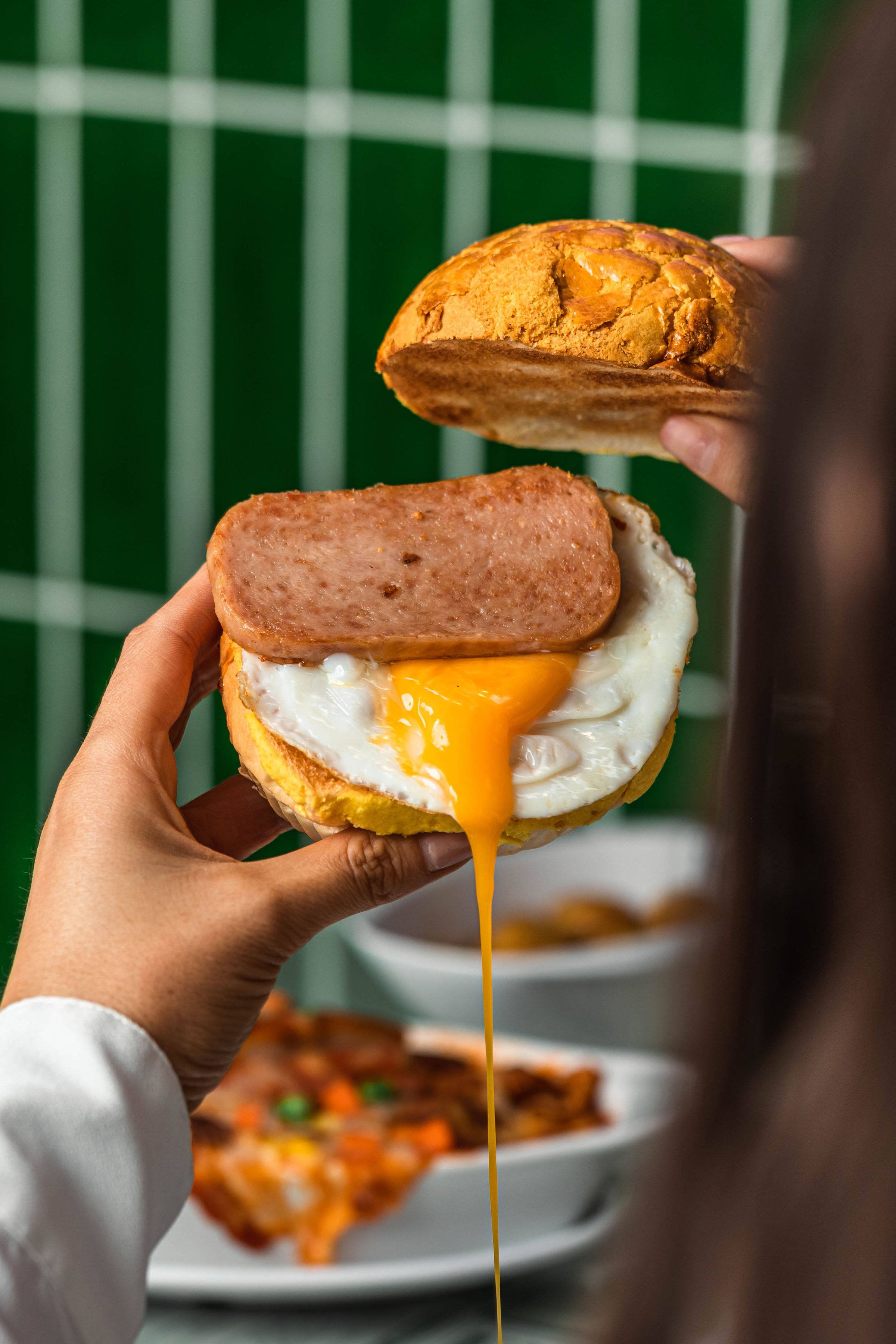 A Spam and egg pineapple bun at Sydney’s Kowloon Cafe. With their neon, familiar decor, even a replica minibus and tram, the Australian city’s Hong Kong-style tea cafes satisfy homesick migrants’ appetite for a dose of nostalgia. 