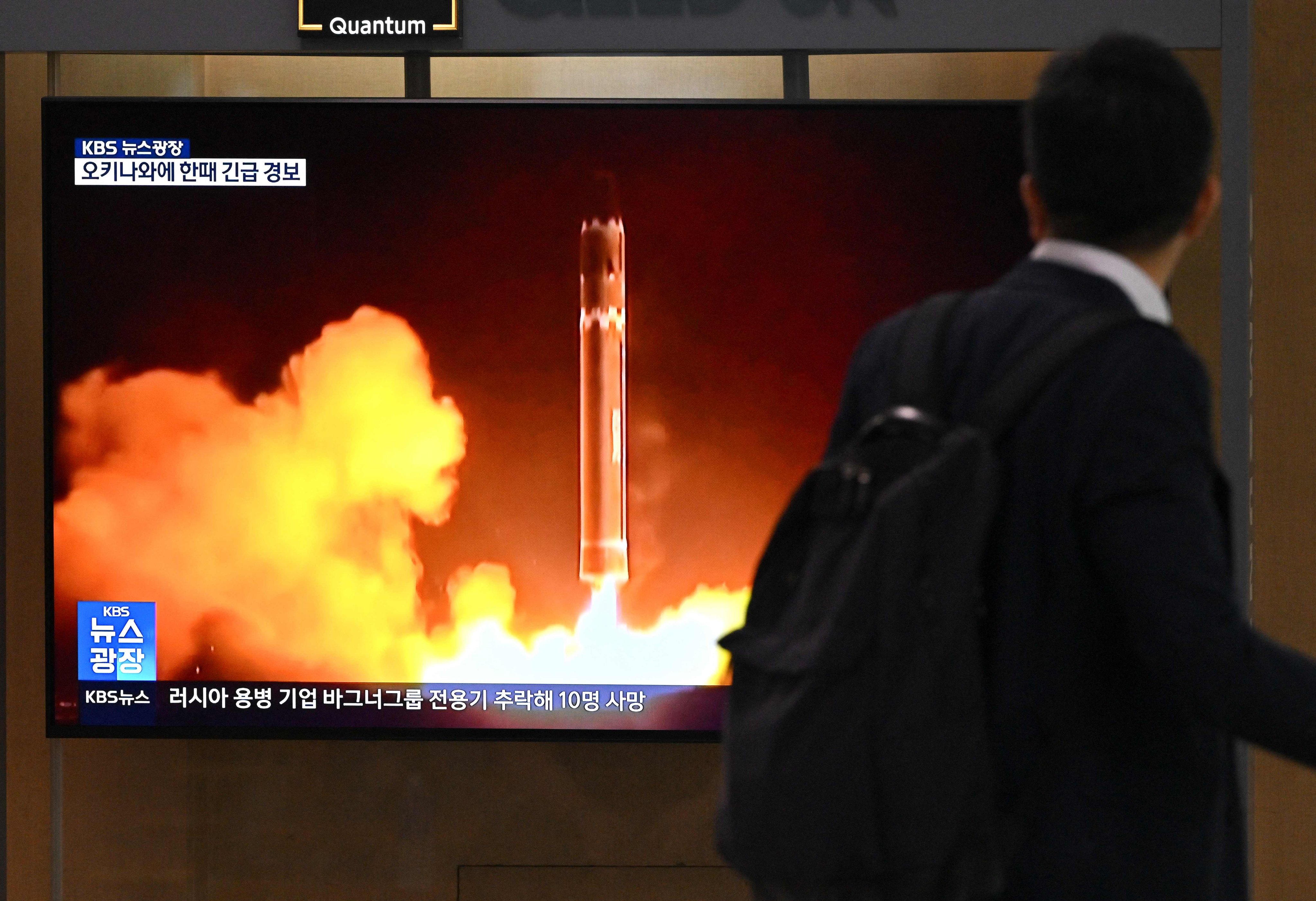 A man walks past a television screen showing a news broadcast with file footage of a North Korean missile test, at a train station in Seoul, South Korea on Thursday. Photo: AFP