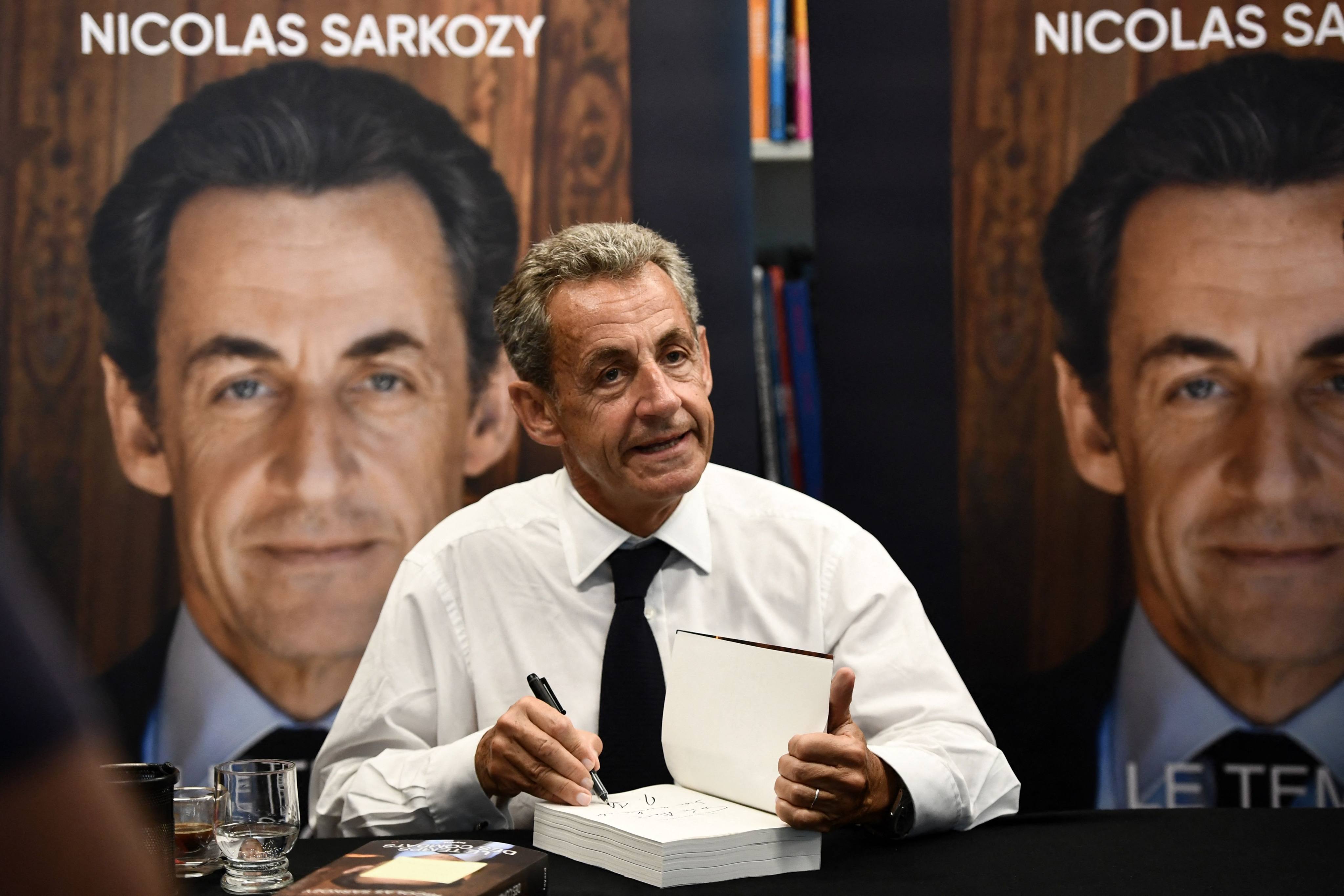 Former French president Nicolas Sarkozy signs copies of his book in Arcachon, France on Friday. Photo: AFP