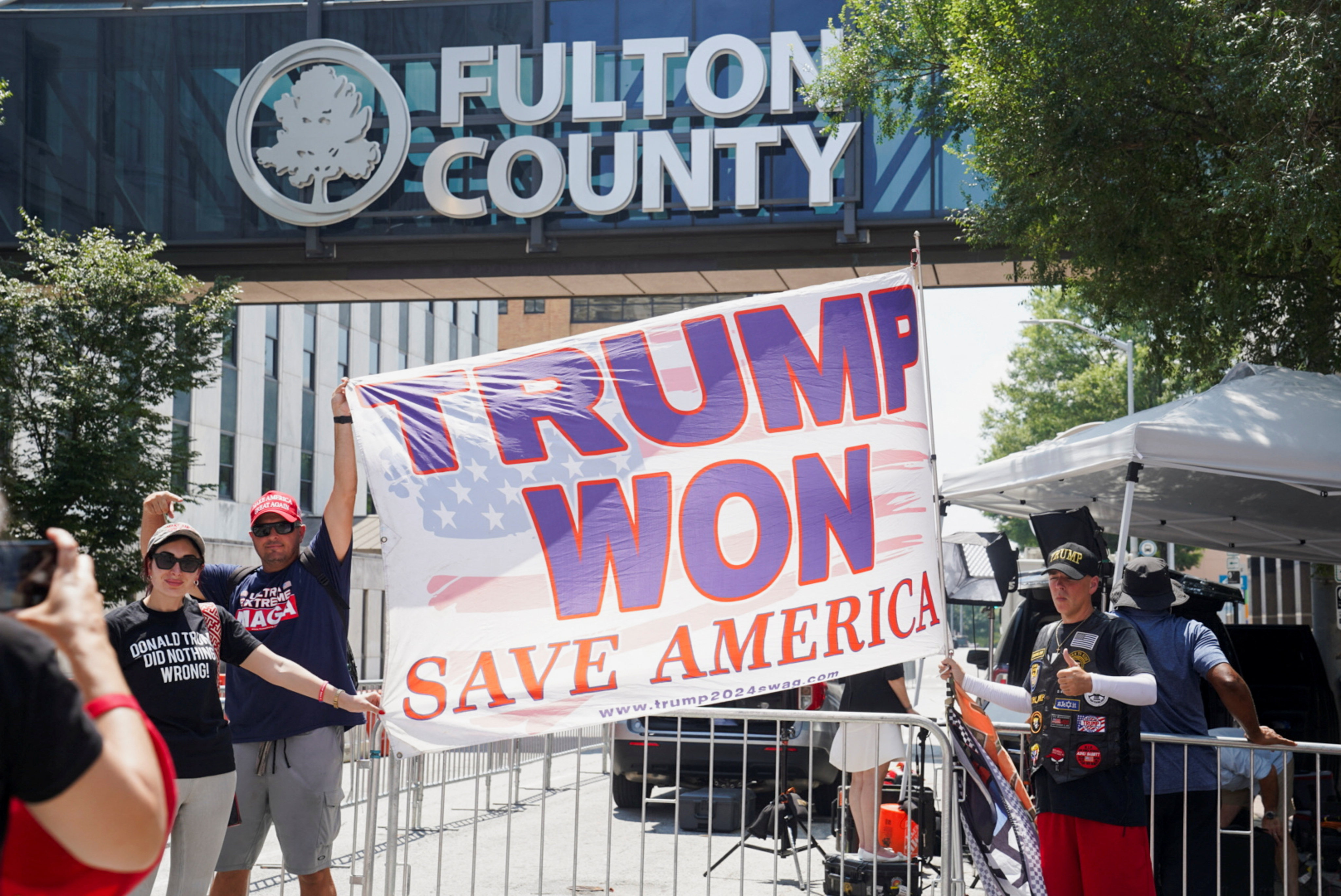 Supporters of former US president Donald Trump hold a flag outside of the Lewis R Slaton Courthouse in Atlanta, Georgia on Friday. Photo: Reuters