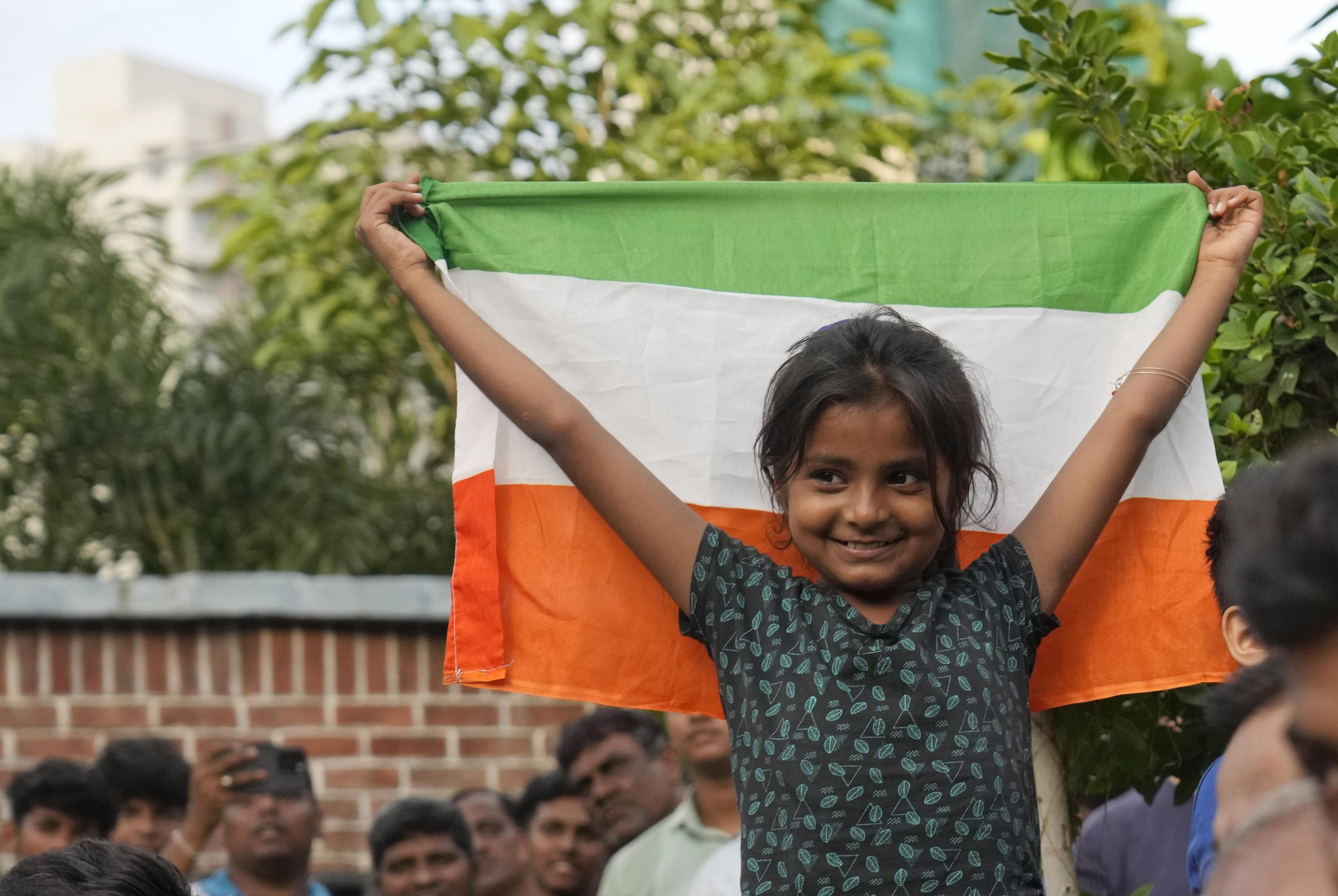 A girl holds aloft the Indian national flag as she watches a live telecast of the moon landing of Chandrayaan-3, in Mumbai, on August 23. Photo: AP
