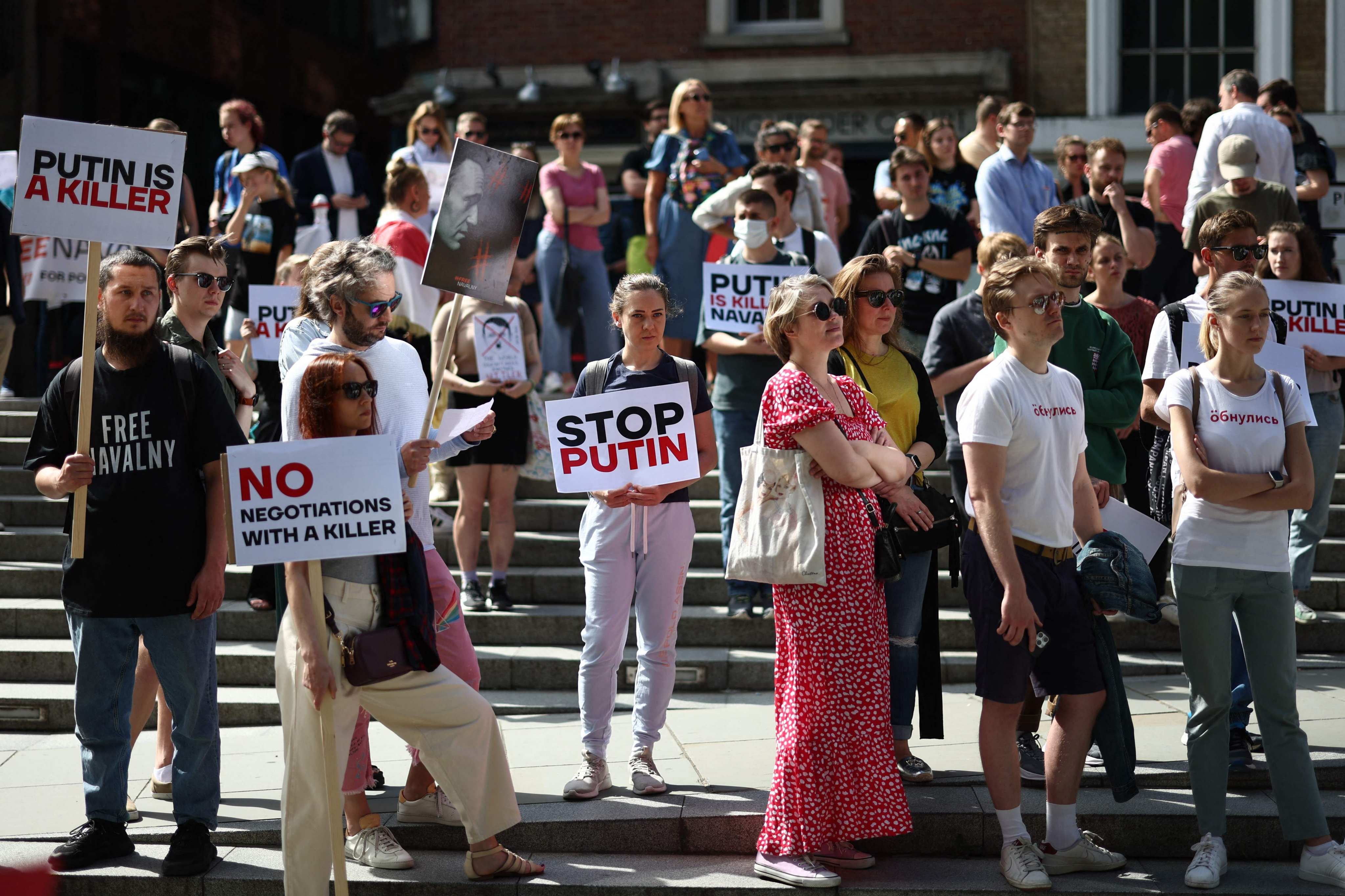 Protesters hold placards against Russian President Vladimir Putin during a demonstration in London on August 20. Photo: AFP 